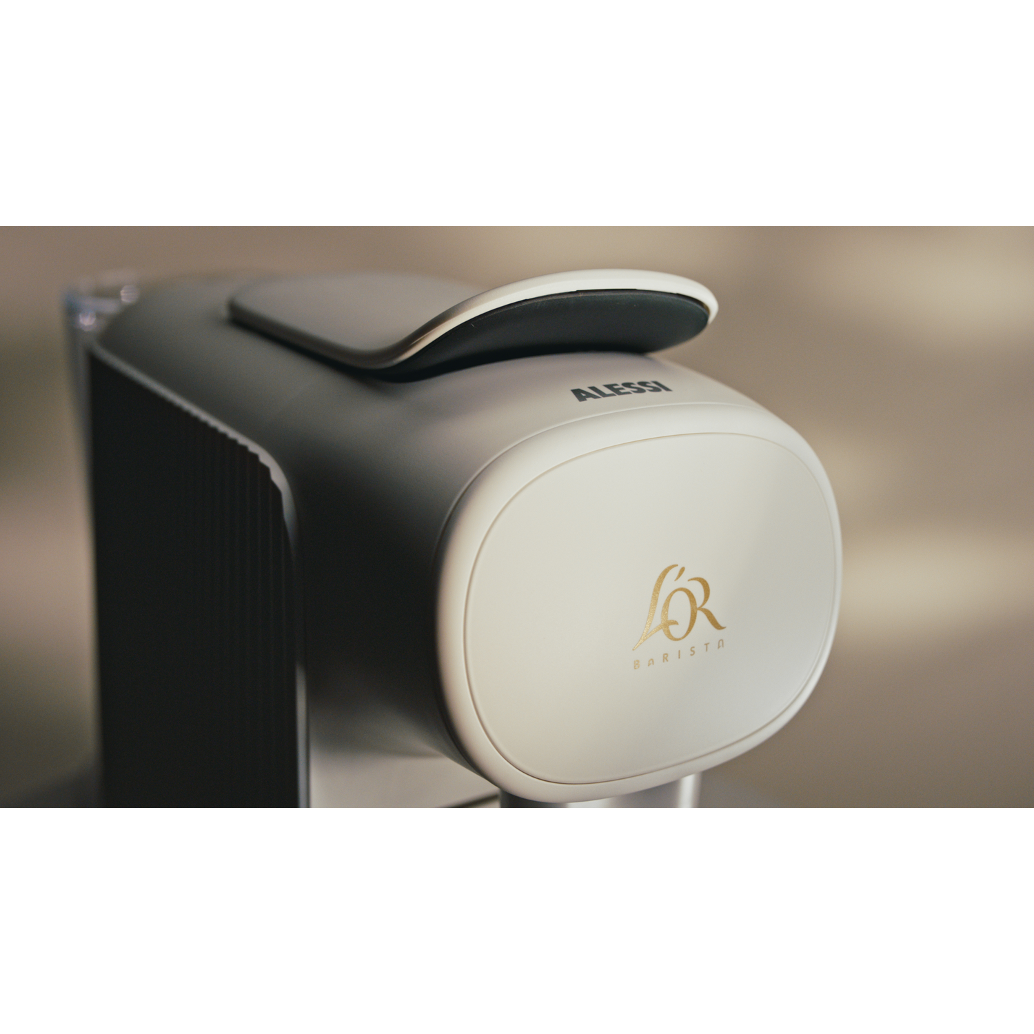 Close-up van een koffiemachine met een witte voorkant, de merknaam en een zwarte bovenkant.