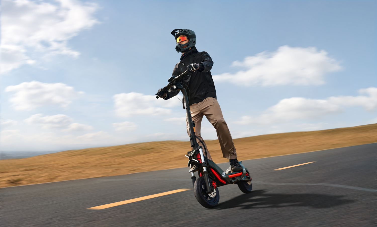 Persona en un scooter montando en una carretera. El fondo es un cielo y una colina.