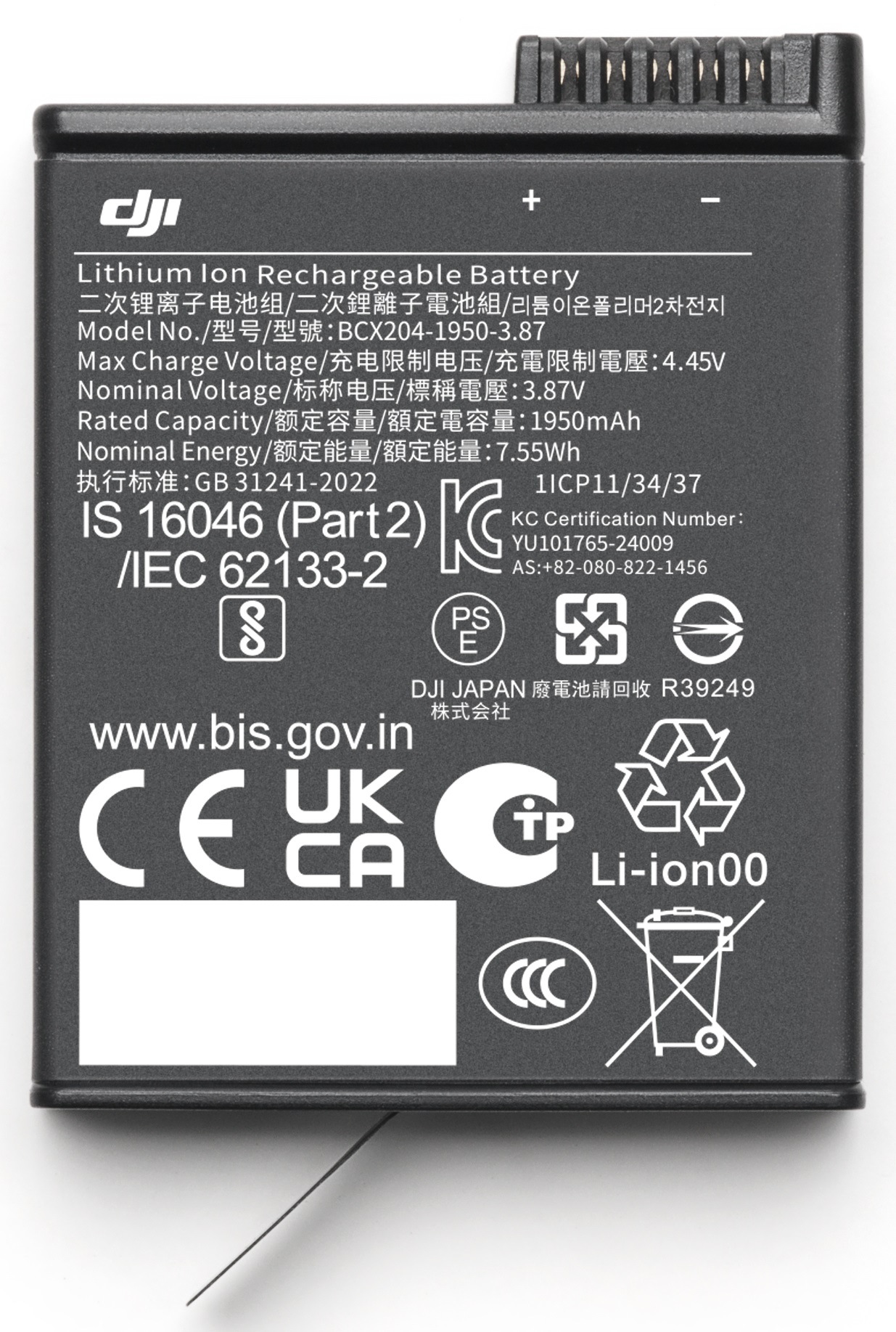 Czarny akumulator z białym tekstem i symbolami, widok z góry.