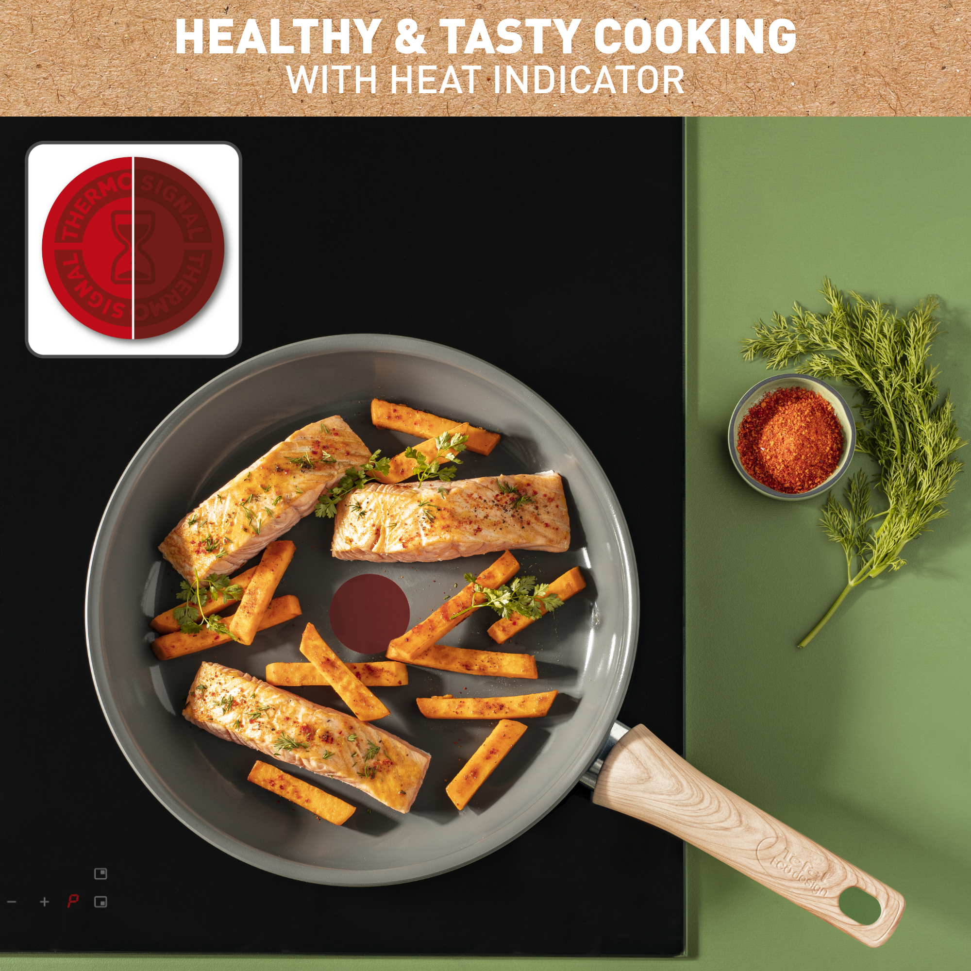 Łosoś i frytki na patelni z drewnianym uchwytem, miska przypraw i zielone tło.