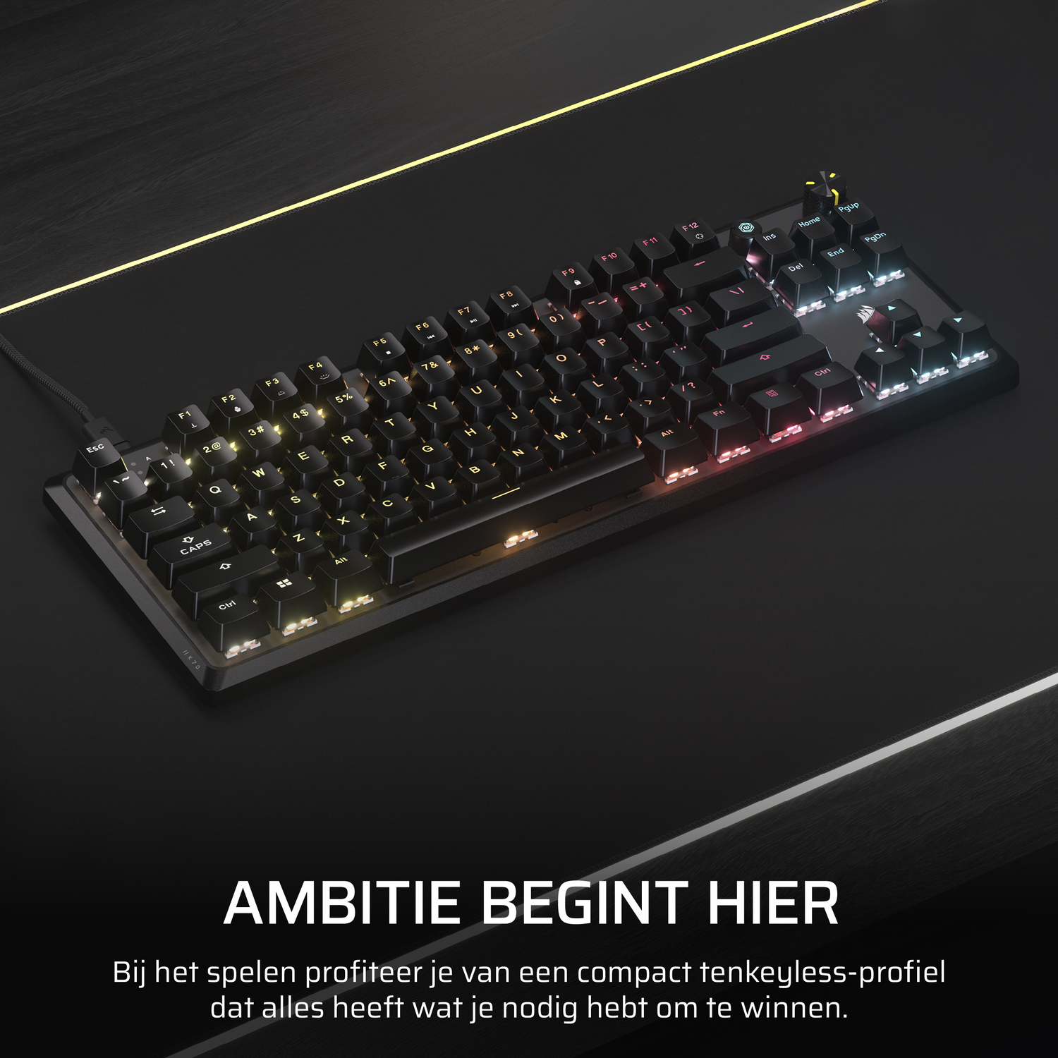 Black keyboard with colorful backlit keys on a black surface, with the words 'AMBITIE BEGINT HIER'.
