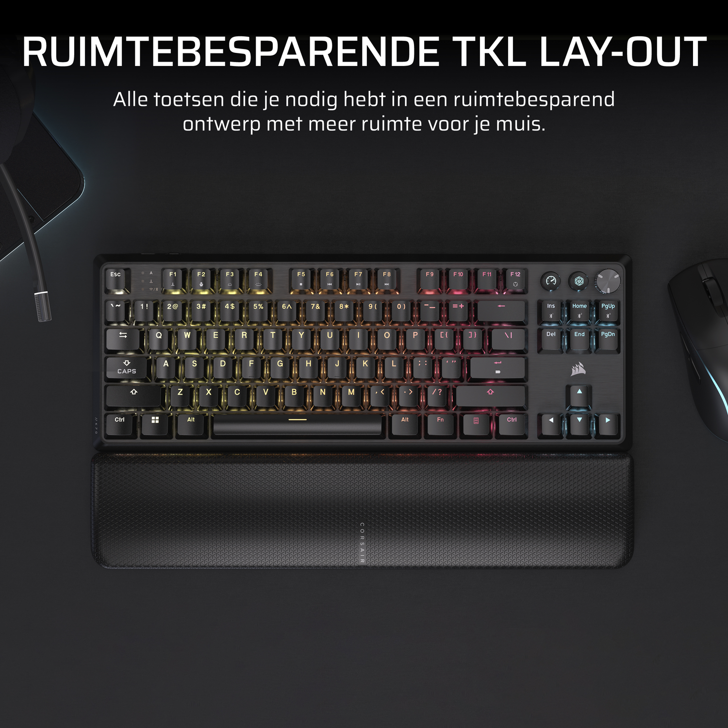 Black keyboard with colored keys and a wrist rest. Black desk with a mouse.