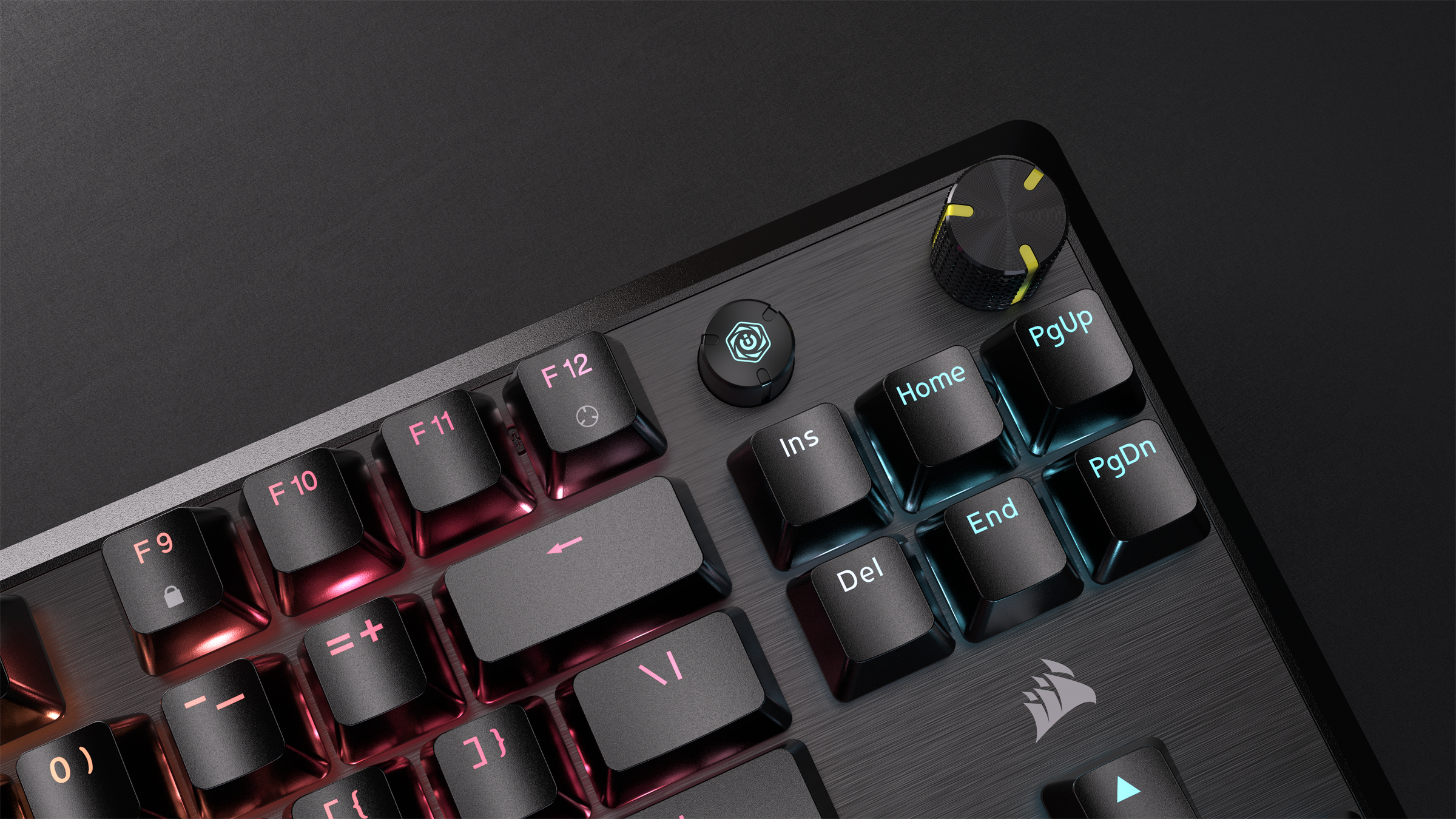 Tastiera con tasti neri, manopola del volume e pulsante di accensione. Illuminazione RGB visibile.