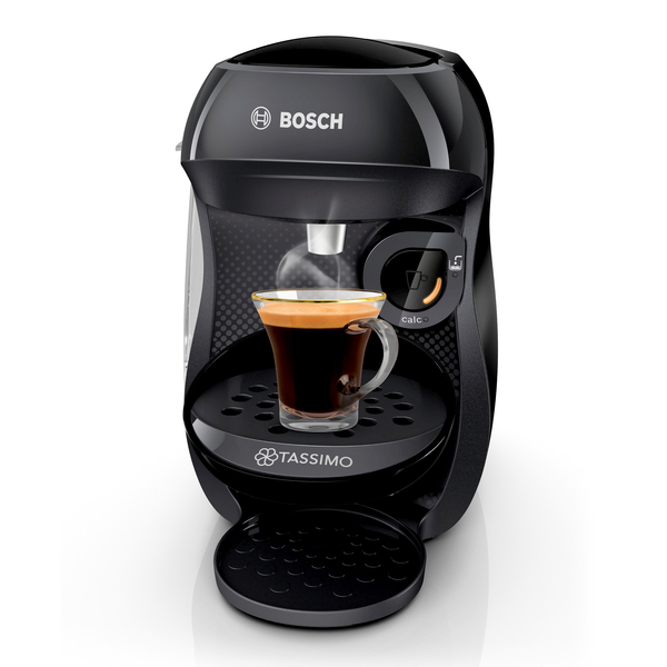 Schwarze Kaffeemaschine mit einem Glasbecher, der mit Kaffee gefüllt ist. Dampf steigt aus der Tasse auf.