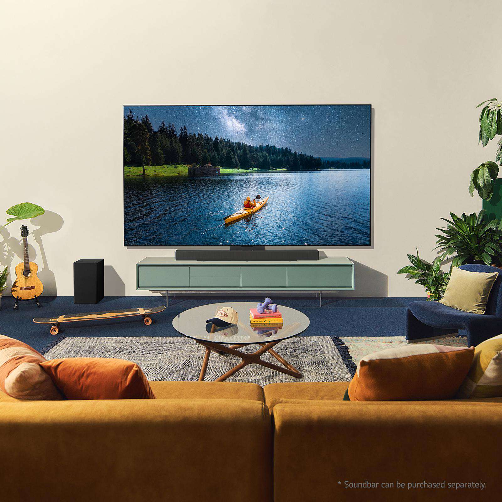 Wohnzimmer mit großem Fernseher, der eine Seelandschaft zeigt. Enthält Möbel und ein Skateboard.