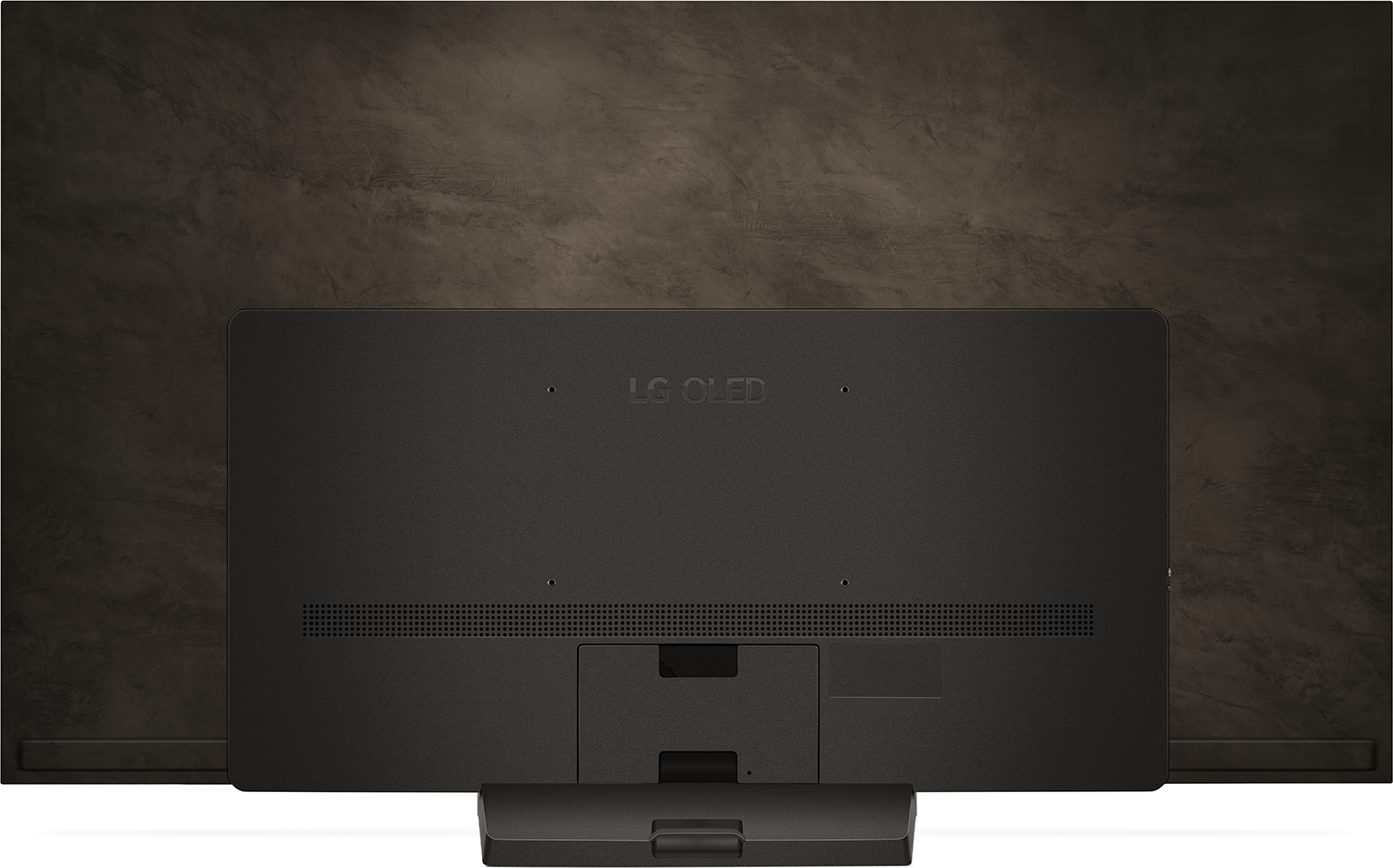 Die Rückseite eines großen schwarzen LG OLED-Fernsehers, montiert an einer braunen Wand.
