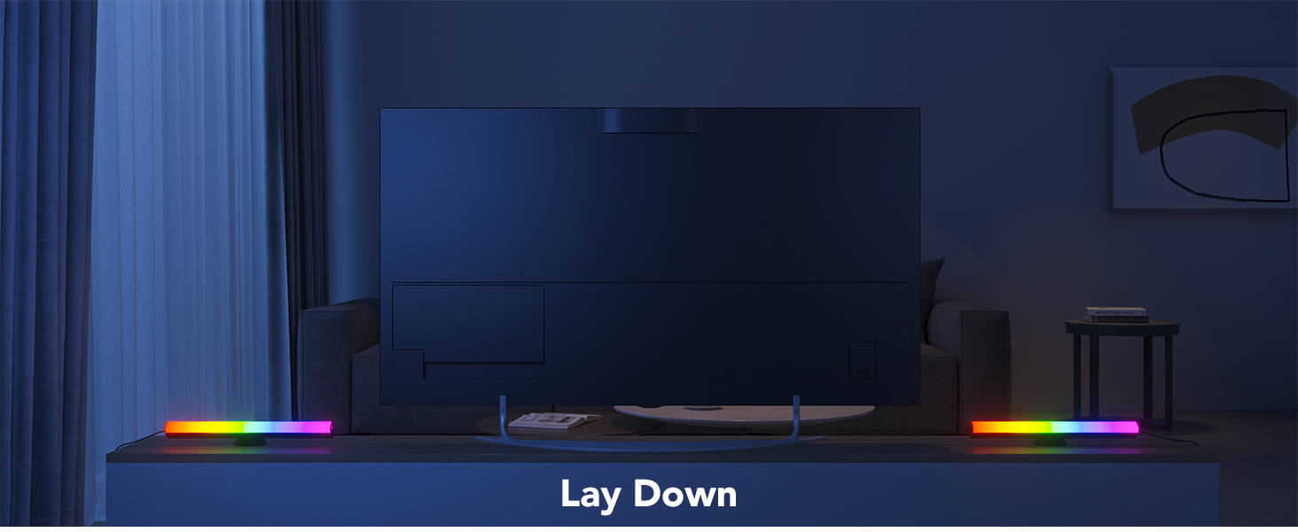 Bir sehpa üzerinde bir TV, LED ışık çubukları ve 'Lay Down' metniyle.