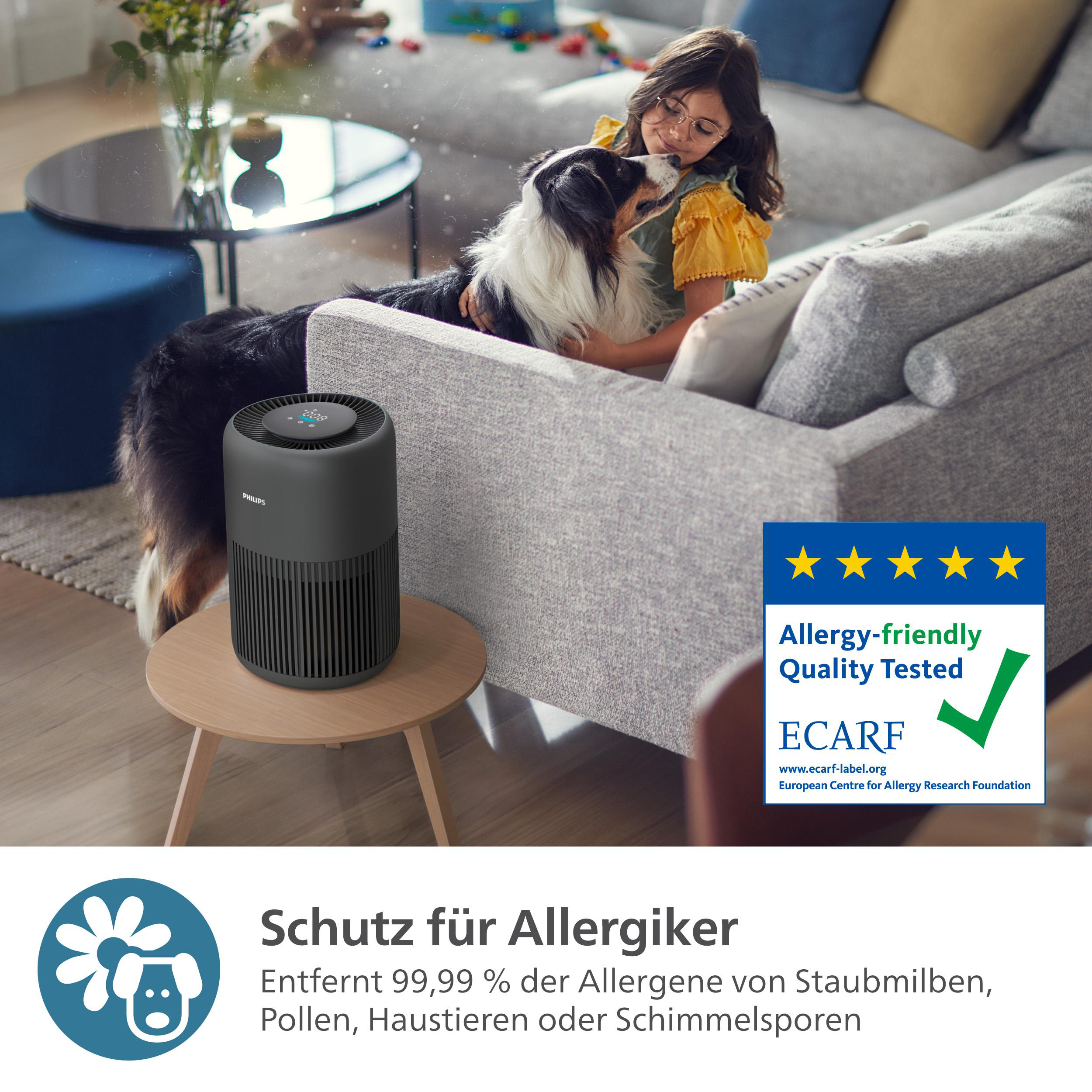 Luftreiniger auf einem Tisch mit Hund und Mädchen. Ein Etikett zeigt die Luftqualität geprüft.