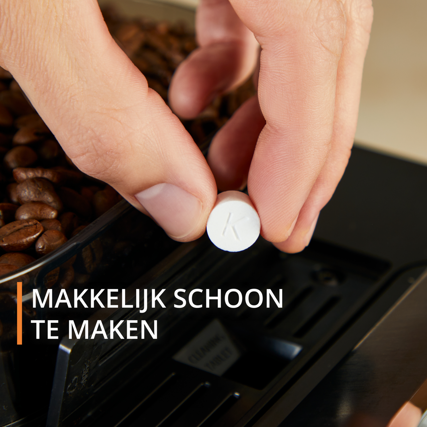 Hand die een witte reinigingstablet in een koffiemachine steekt, tekst: Gemakkelijk schoon te maken.