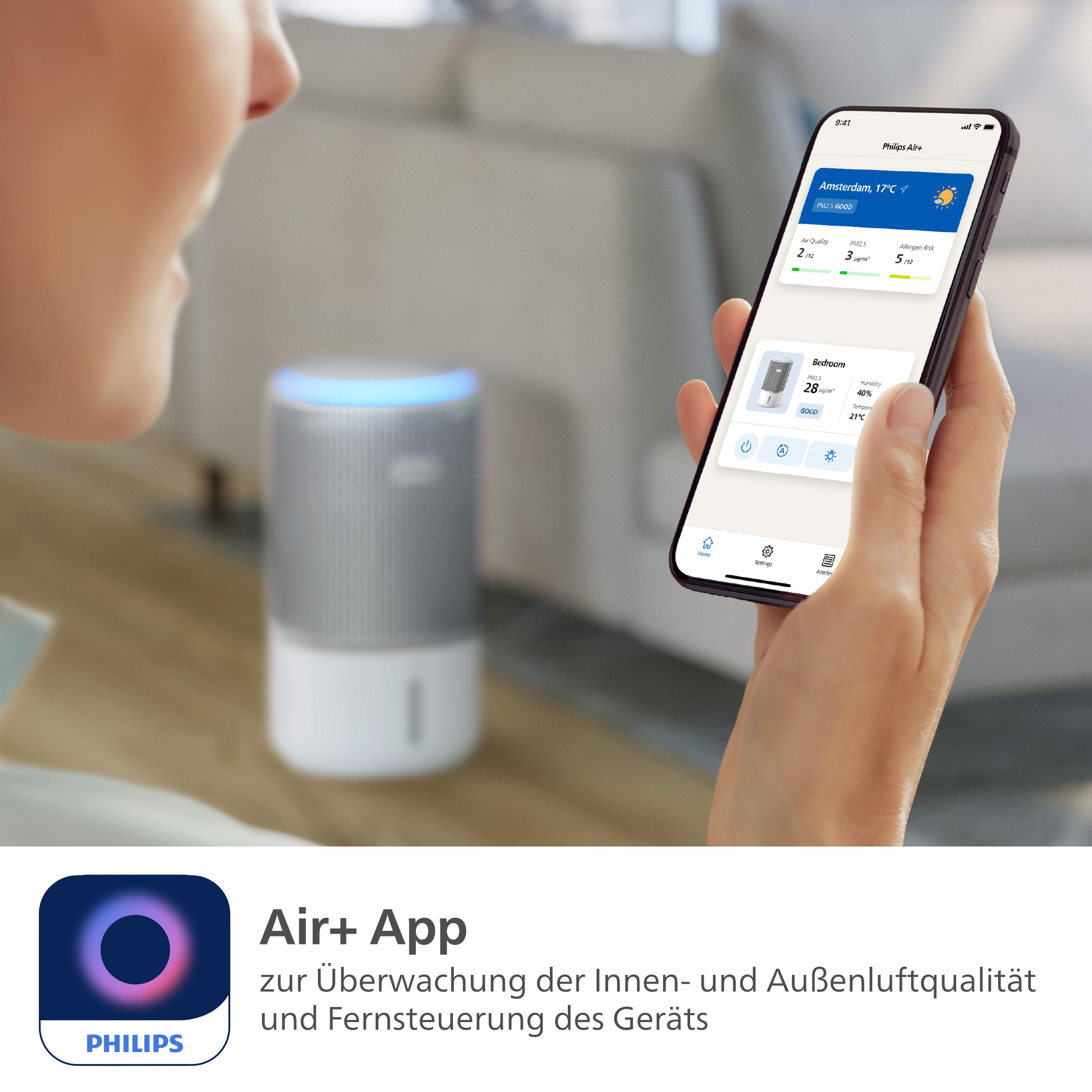 Person hält ein Telefon mit Luftqualitätsmesswerten. Ein Lautsprecher steht hinter dem Telefon.