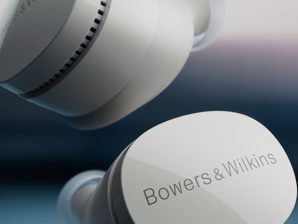 Zbliżenie białych słuchawek z logo Bowers & Wilkins na niebieskim tle.