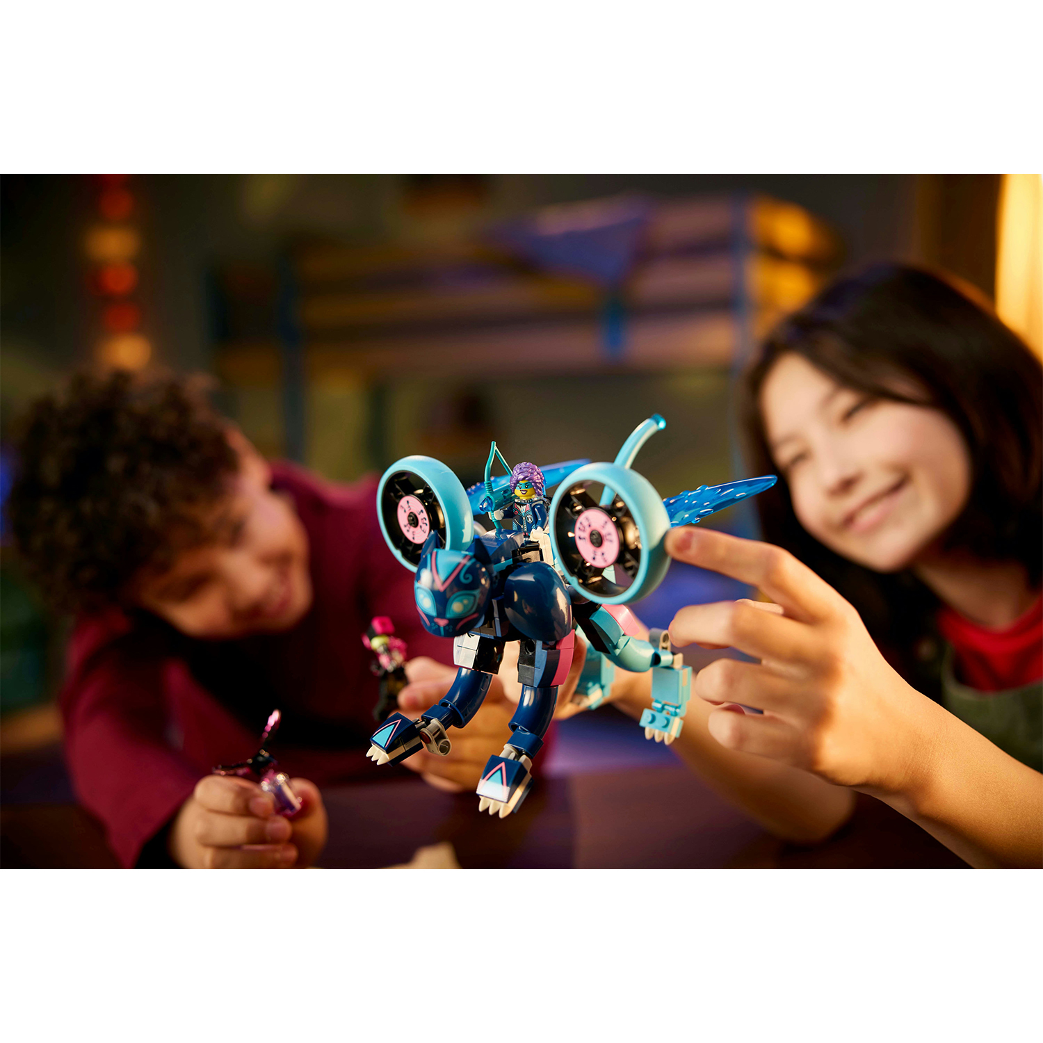 Due bambini che giocano con un set Lego di un robot blu con le ali.