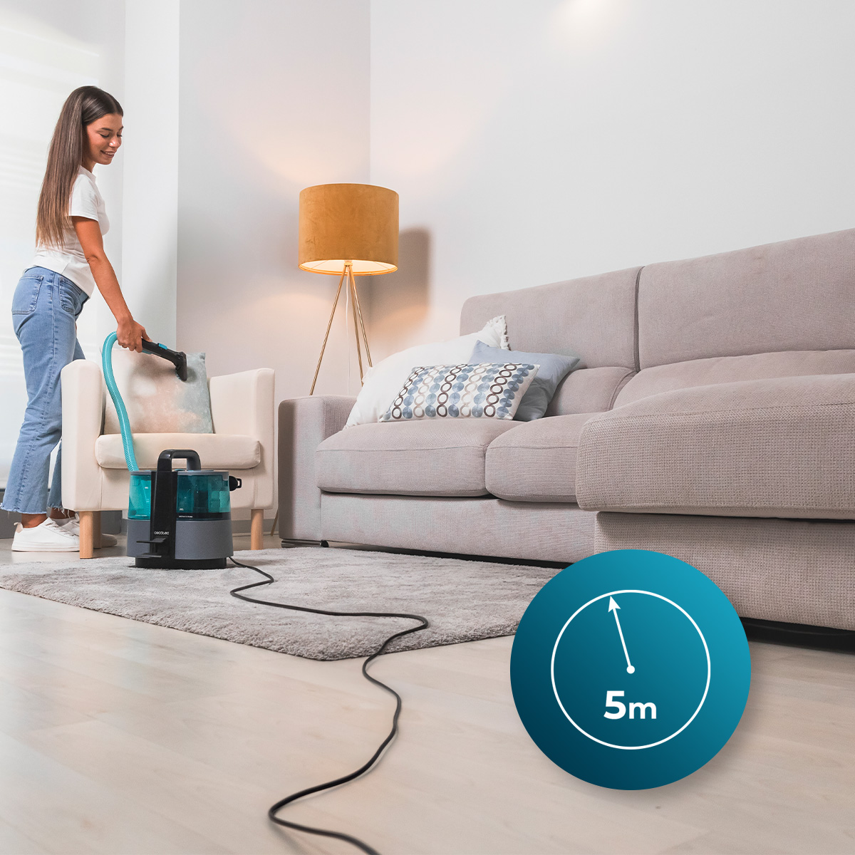 Mujer limpiando sofá con máquina, temporizador 5m, en sala de estar.