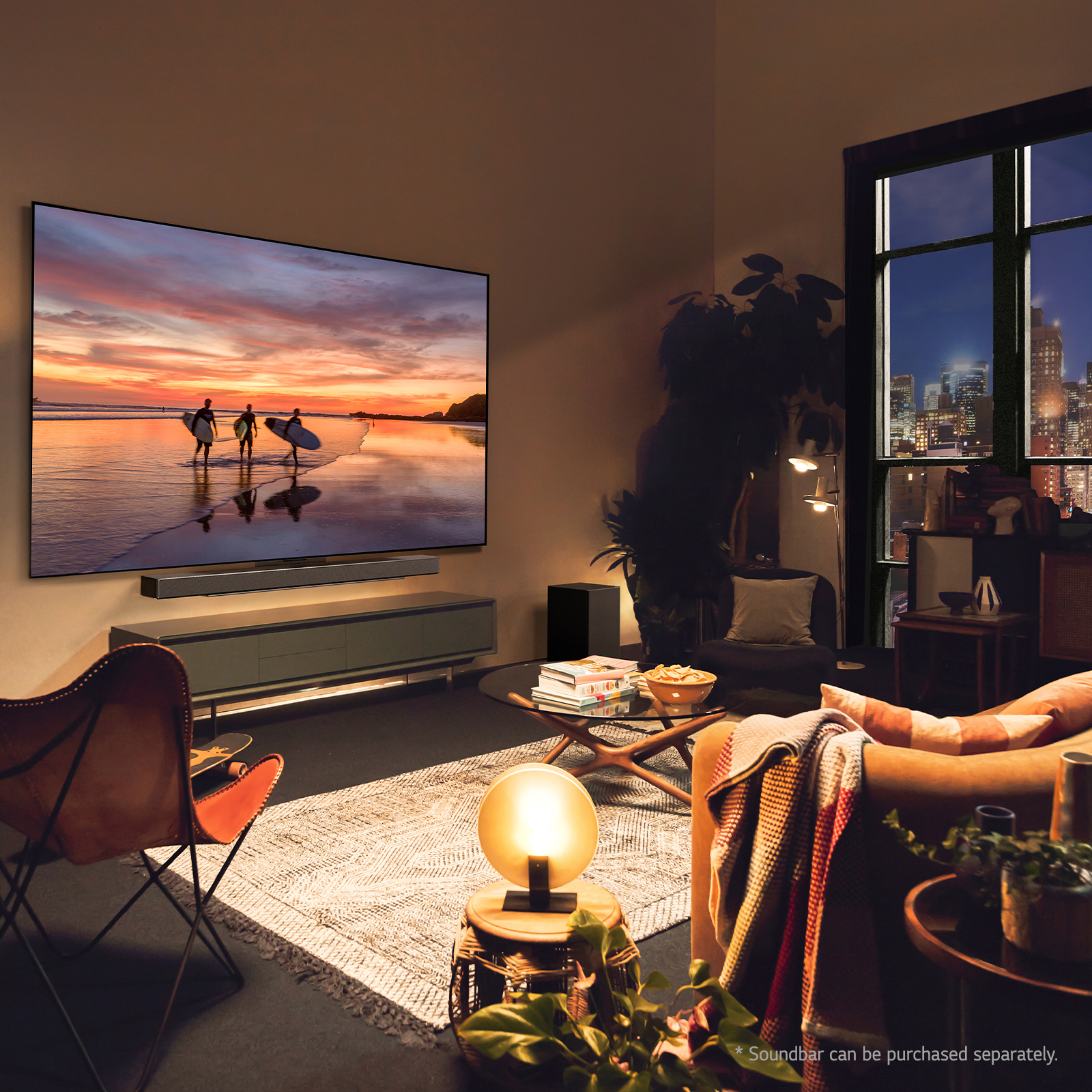 Wohnzimmer mit großem Fernseher, Soundbar und Fenster mit Nacht-Stadtlandschaft.