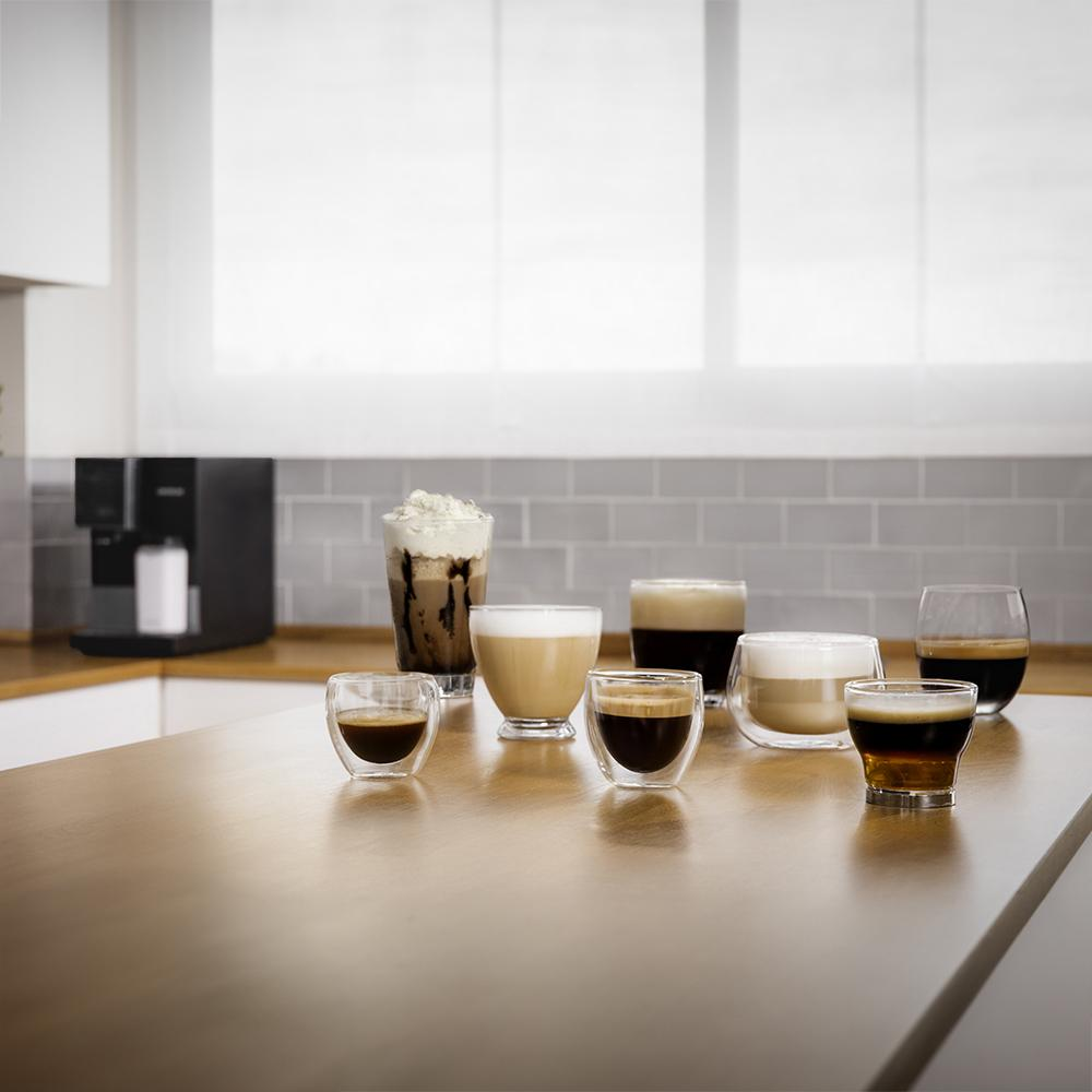 Varias bebidas de café en vasos de vidrio sobre una encimera de madera.