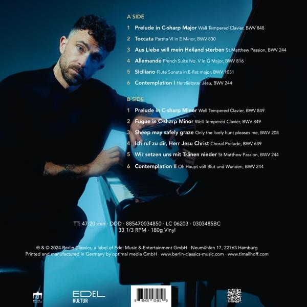 Eine Schallplatte mit Titelliste und ein Mann mit Bart, der die Platte betrachtet.