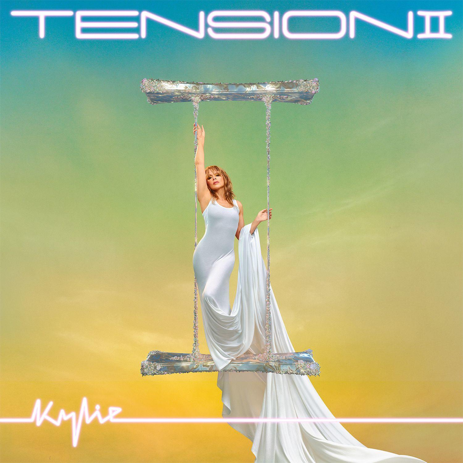 Albumcover: Kylie auf einer Schaukel. Sie trägt ein weißes Kleid, mit Text 'TENSION' oben und 'Kylie' unten.