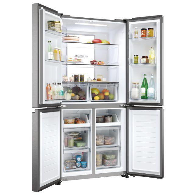 Offener Kühlschrank mit Essen. Regale mit verschiedenen Artikeln und Schubladen darunter.