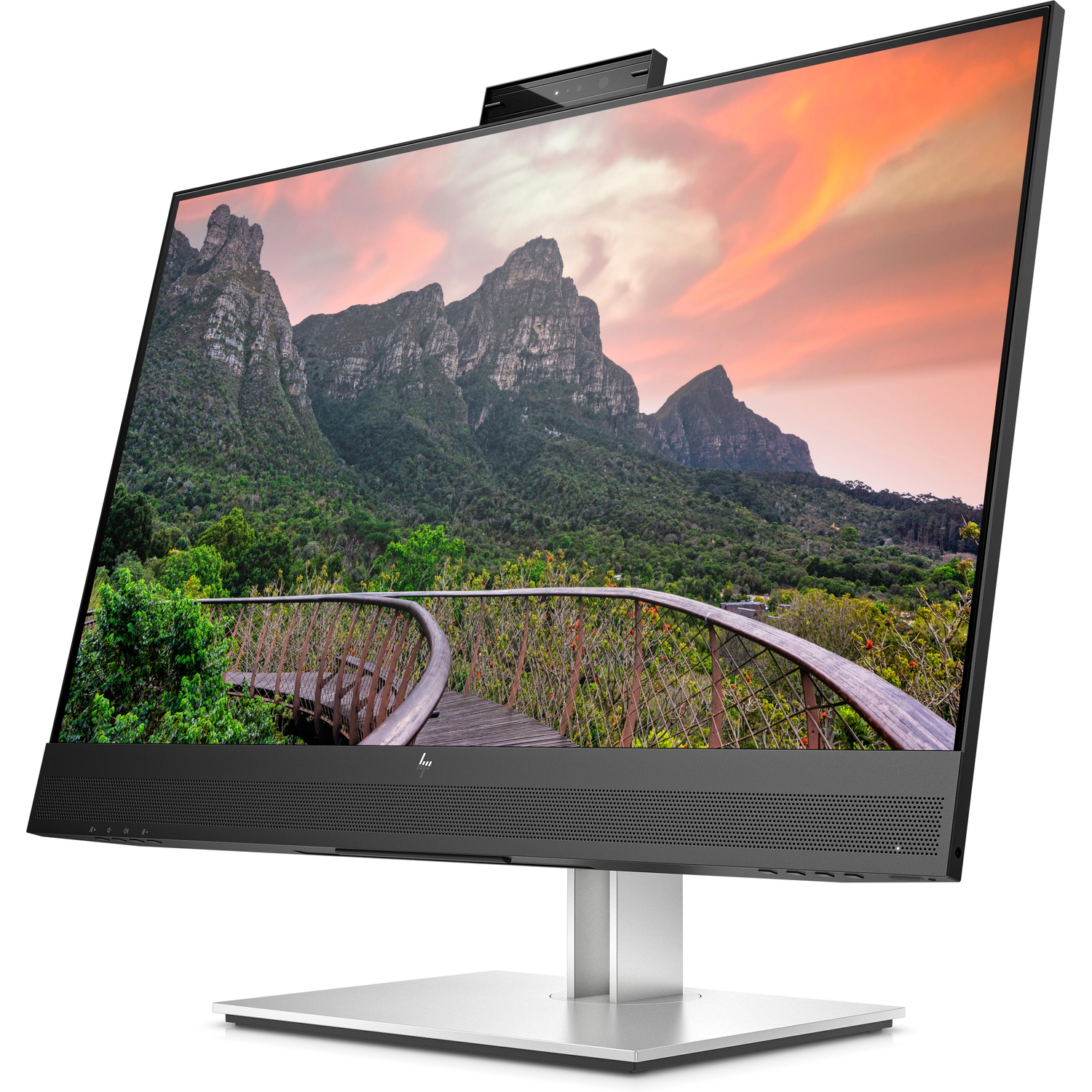 A computer monitor displays a landscape with mountains, a bridge, and trees with a clear sky.
