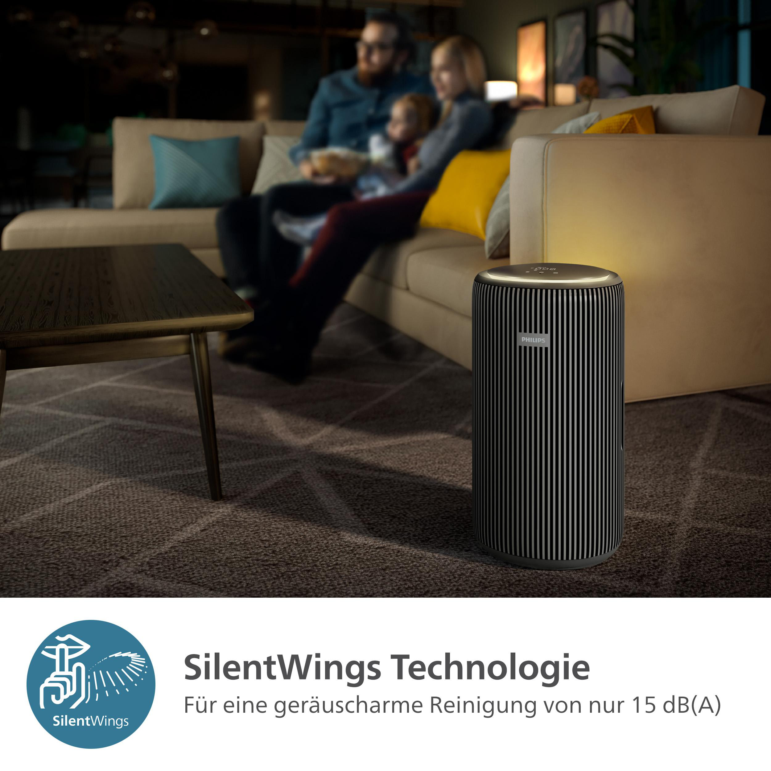 Ein Luftreiniger. Menschen auf einem Sofa im verschwommenen Hintergrund. SilentWings-Technologie-Logo unten.