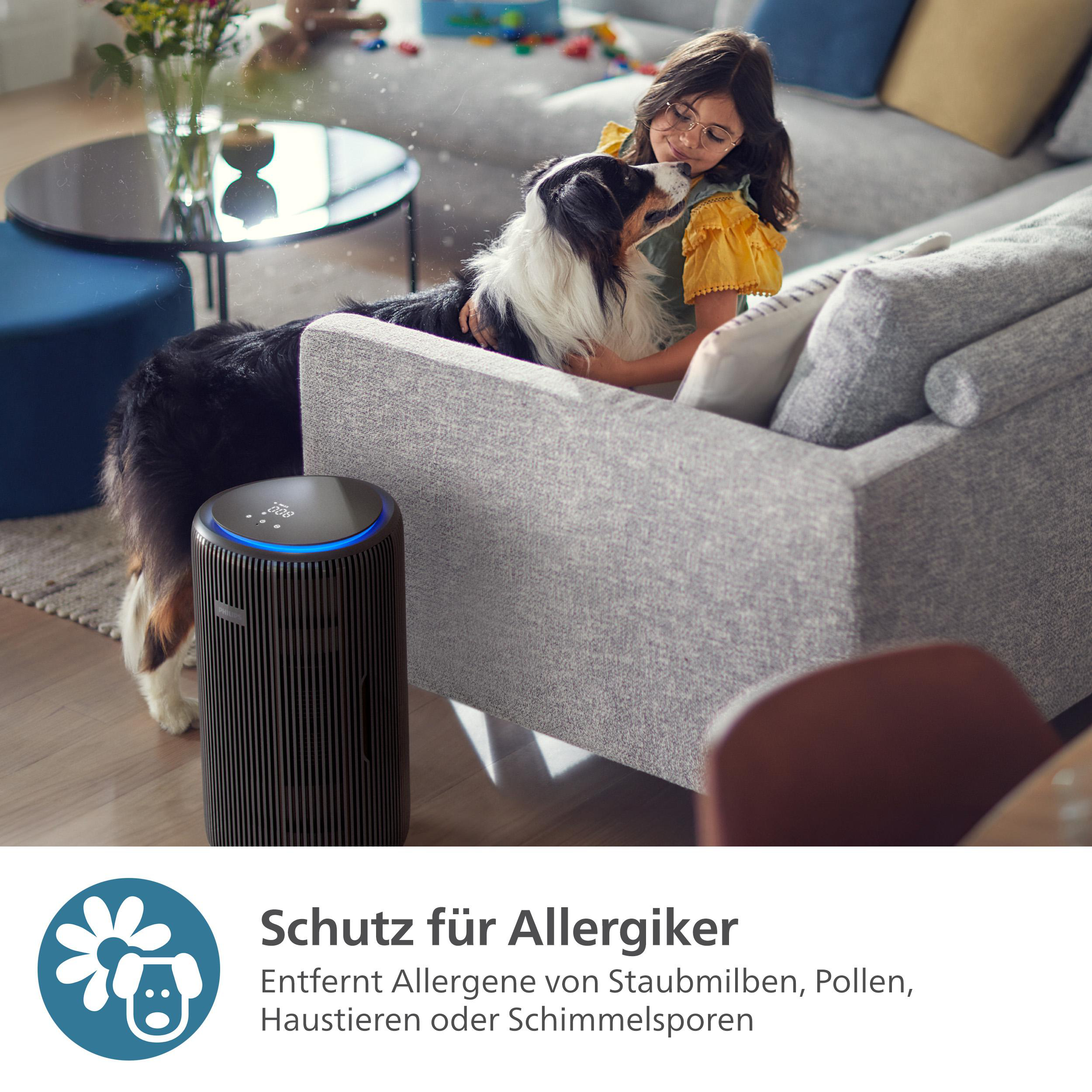 Mädchen und Hund auf einem Sofa. Luftreiniger im Hintergrund.