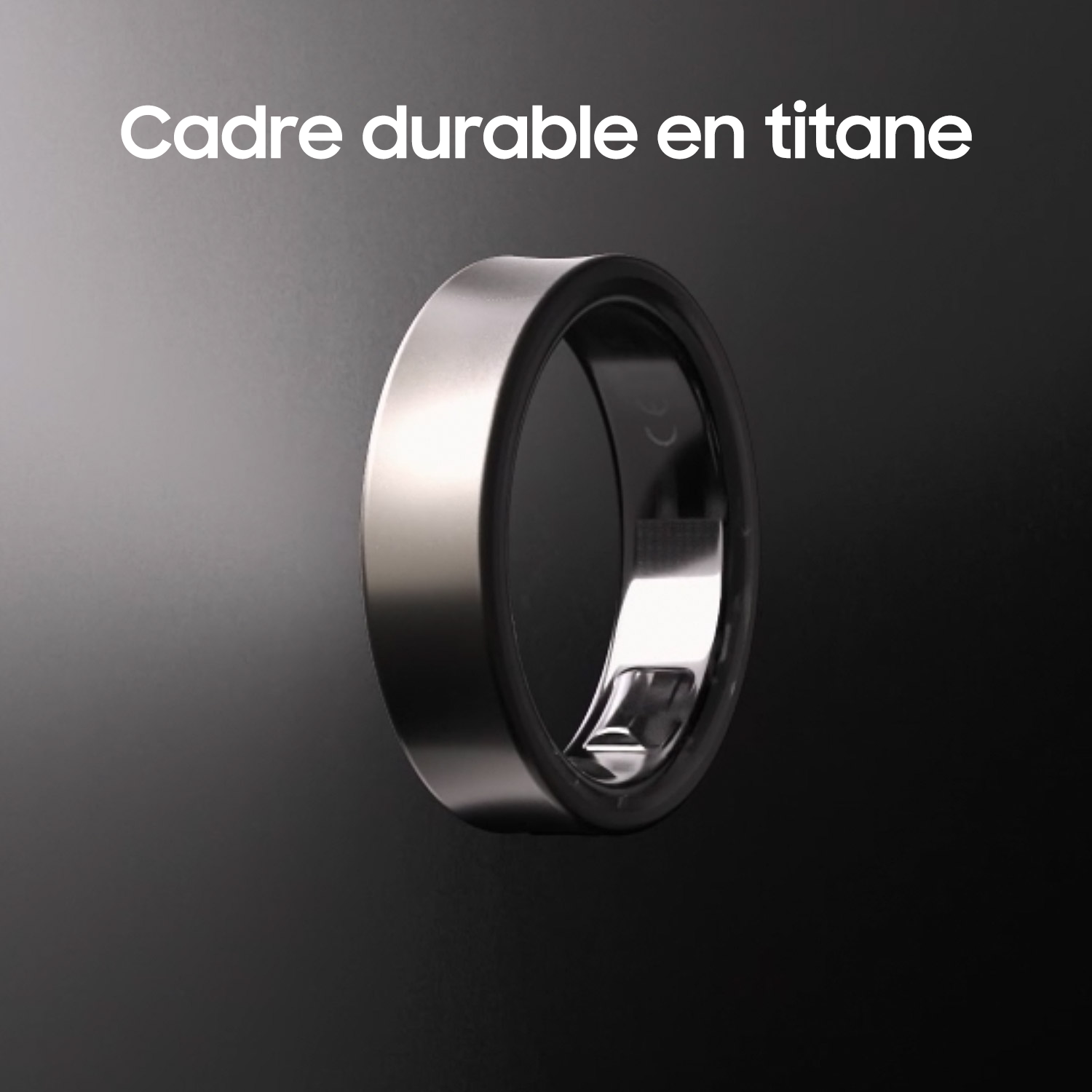 Une bague argentée avec une bande intérieure noire sur fond sombre.