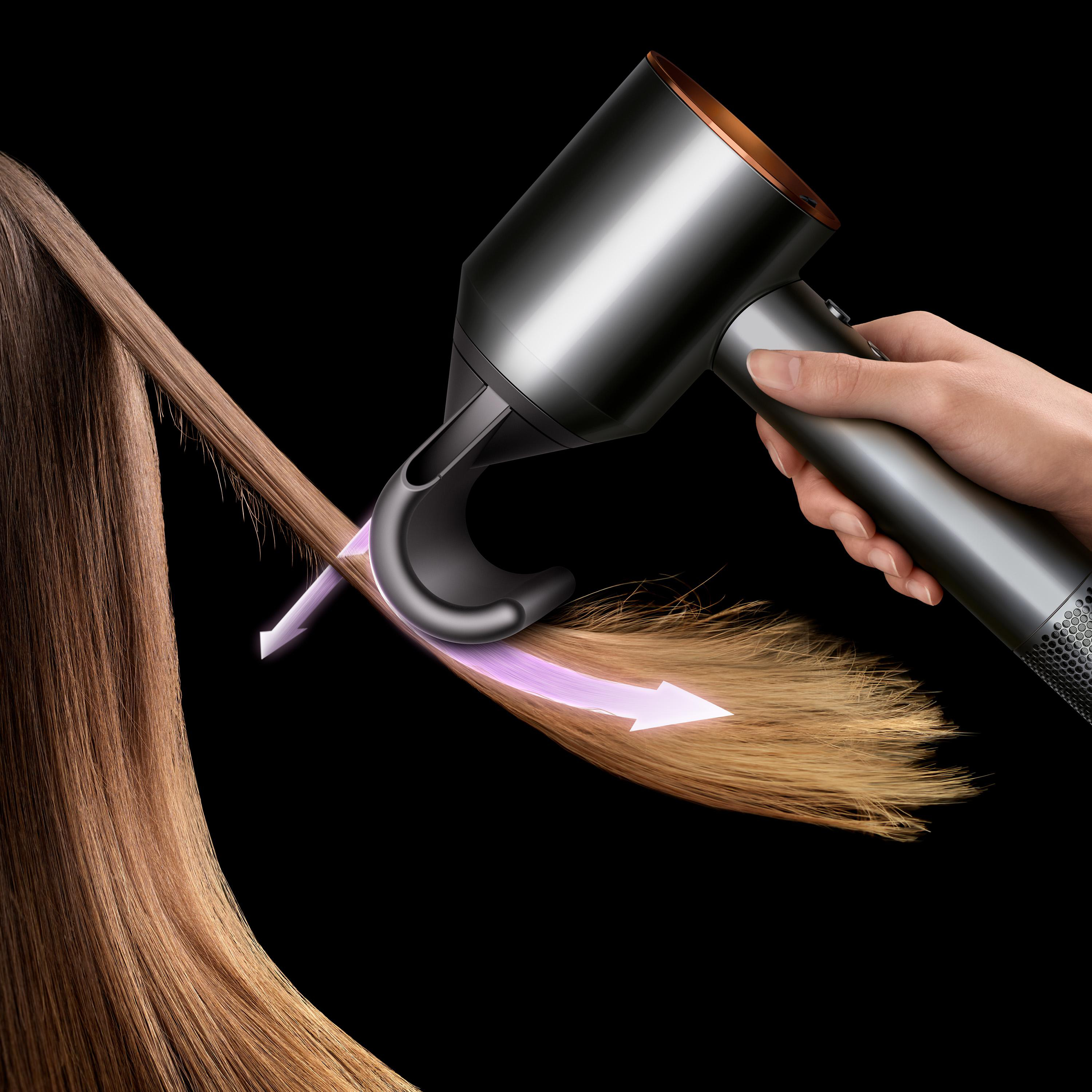Eine Hand hält einen Föhn, der Haare trocknet, wobei Pfeile die Luftstromrichtung anzeigen.