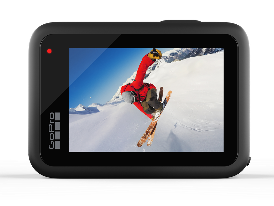 Kamera GoPro pokazująca narciarza w powietrzu na tle zaśnieżonych gór.