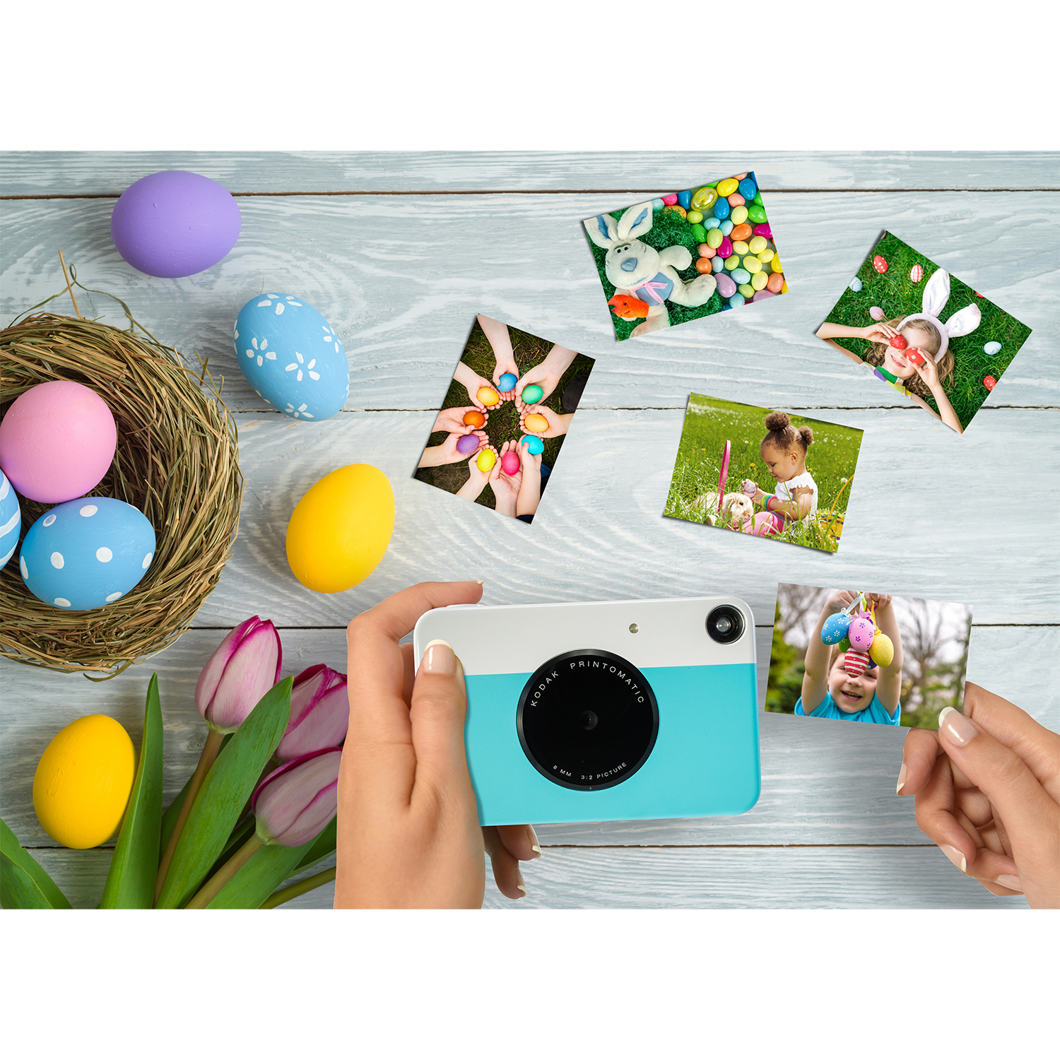 Mani che tengono foto con immagini pasquali, circondate da uova di Pasqua e una fotocamera.