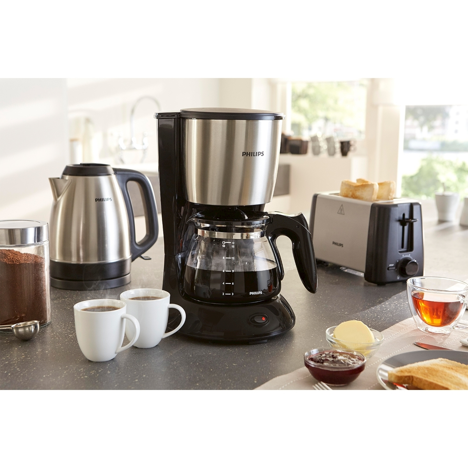 Una scena della colazione con una caffettiera, un bollitore, un tostapane e articoli per la colazione.
