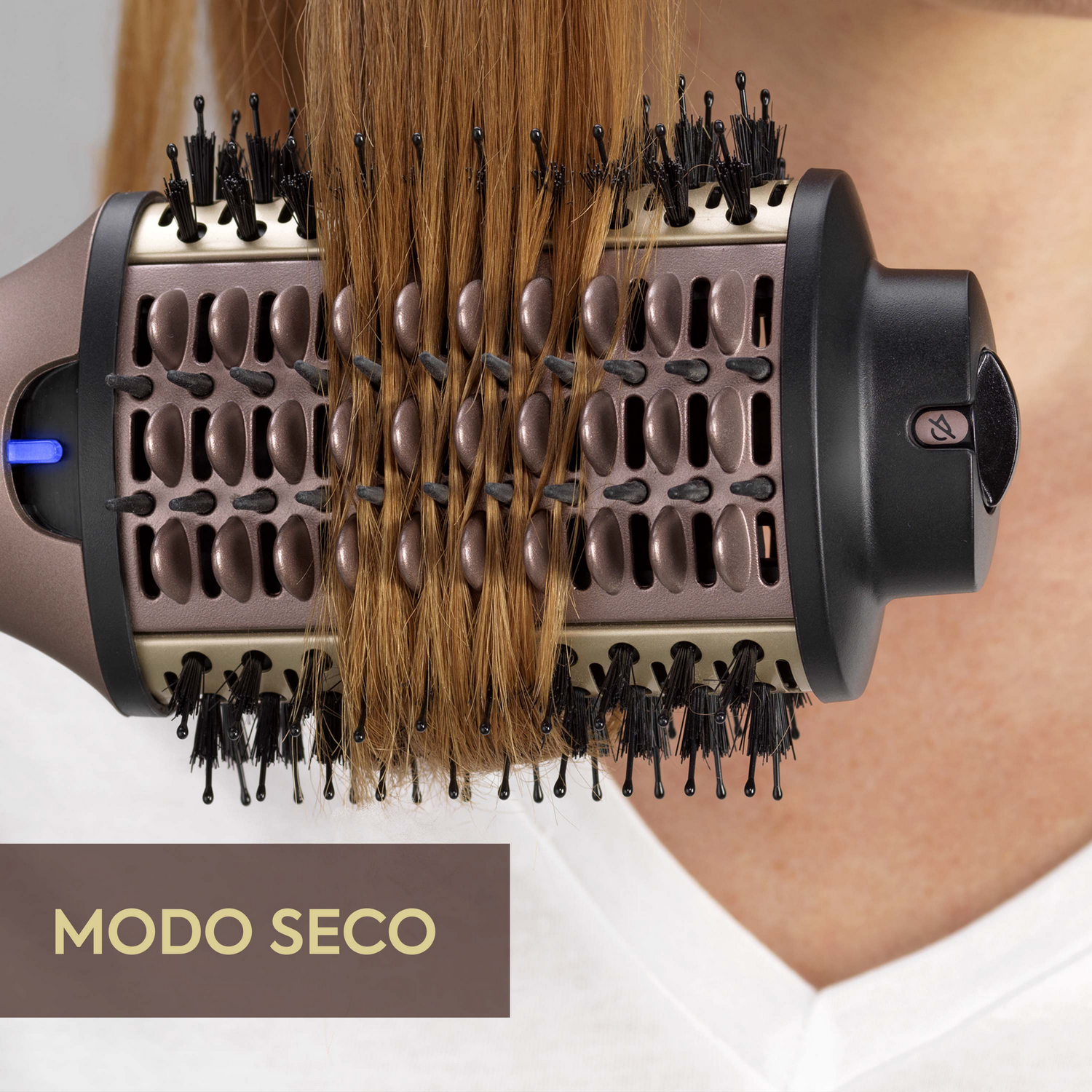 Un cepillo para peinar el cabello con cerdas marrones y un cuerpo marrón y negro, con el texto 'MODO SECO'.