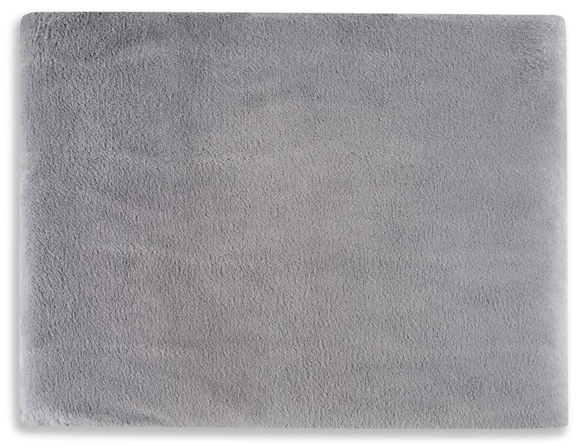 Prostokątny, szary, puszysty dywan na białej powierzchni.