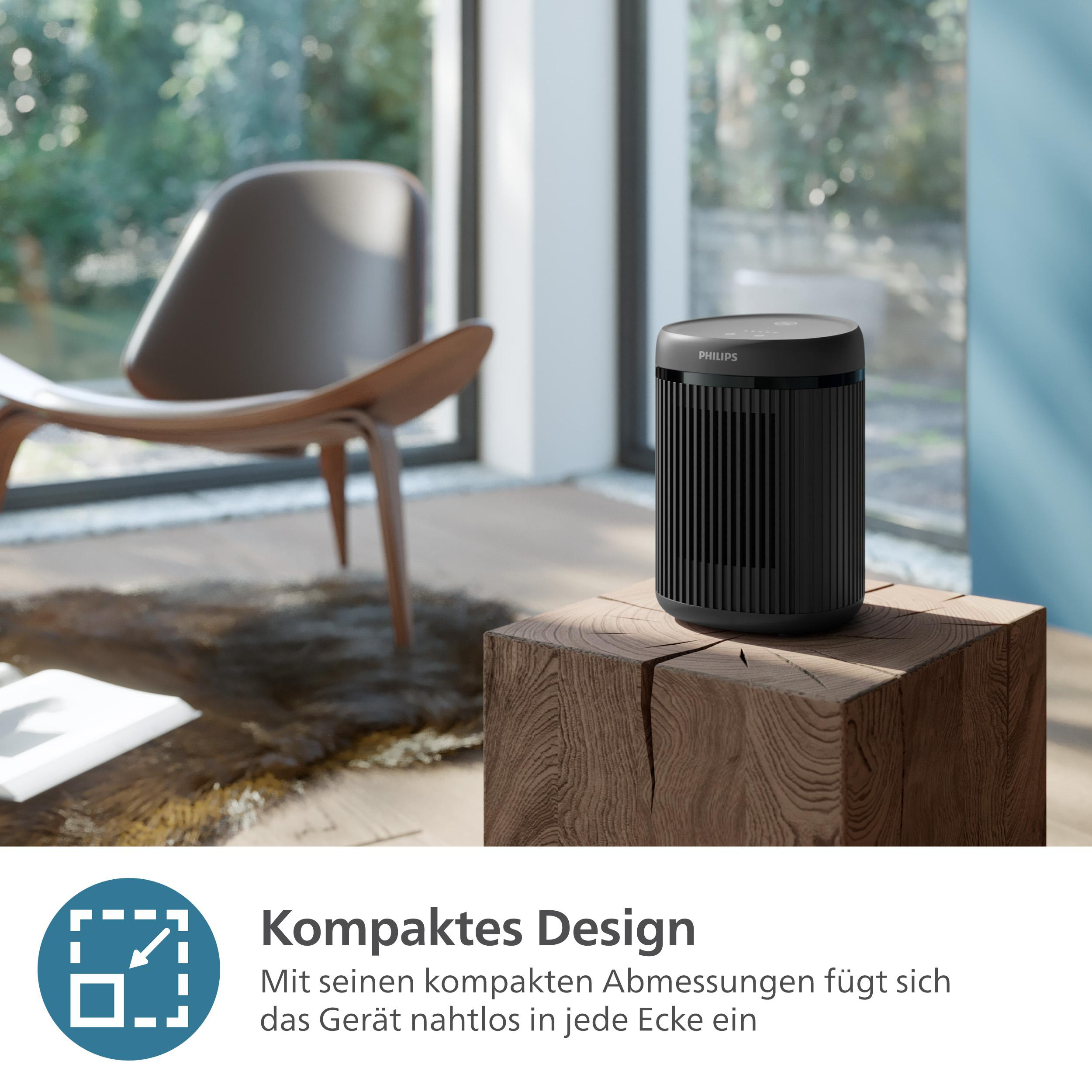Schwarzer Luftreiniger auf einem Holzblock in einem Raum.