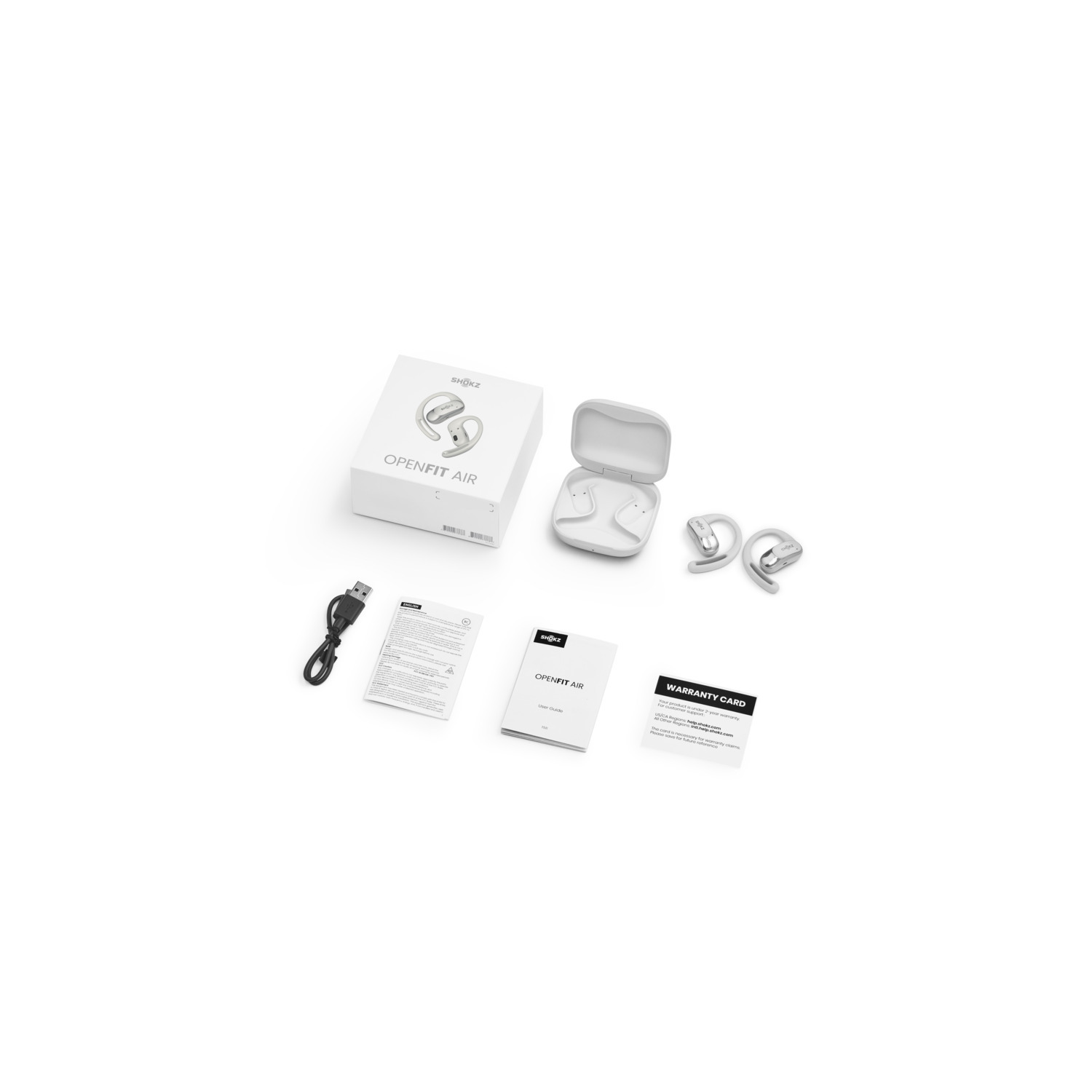 Écouteurs blancs, étui de charge, boîte, câble et documents sur fond blanc.