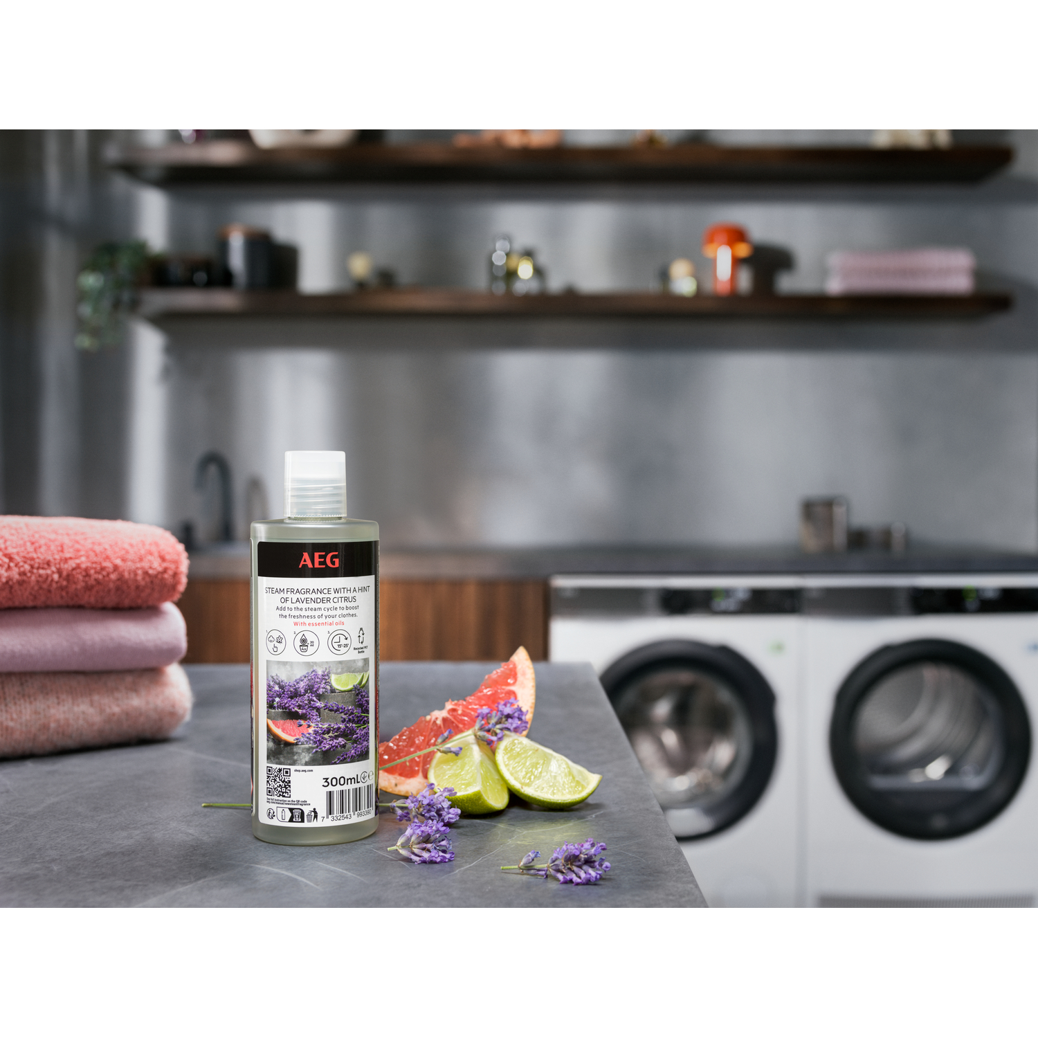 Bouteille de parfum vapeur avec articles de lessive et appareils en arrière-plan.