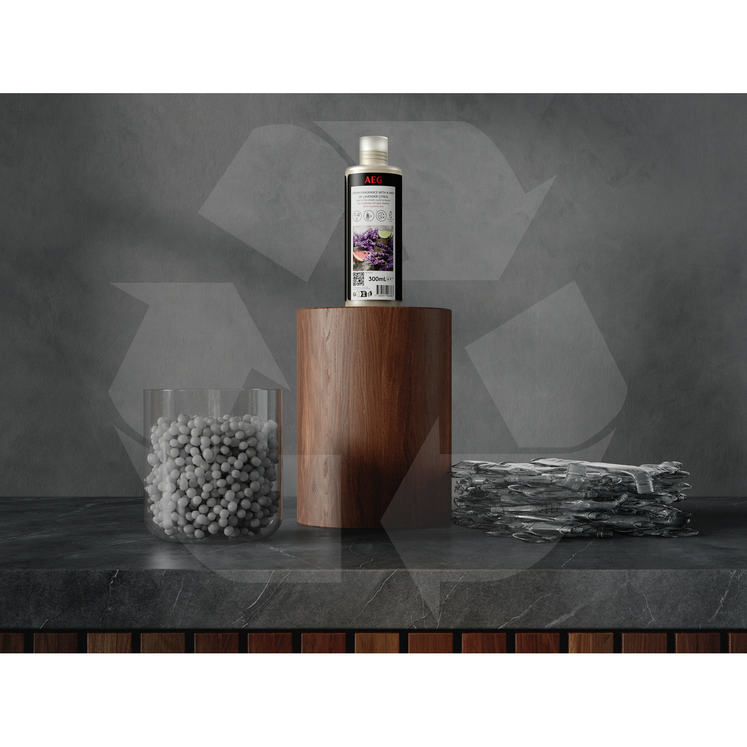 Une bouteille sur un support en bois, un verre avec des boules blanches et une pile de plastique sur une surface grise.