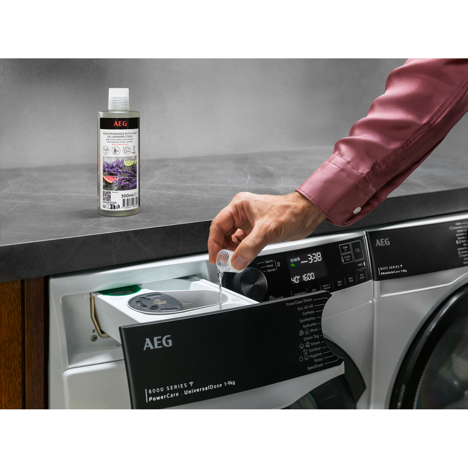 Une personne verse du détergent d'une bouteille dans le tiroir d'une machine à laver. Machine AEG visible.