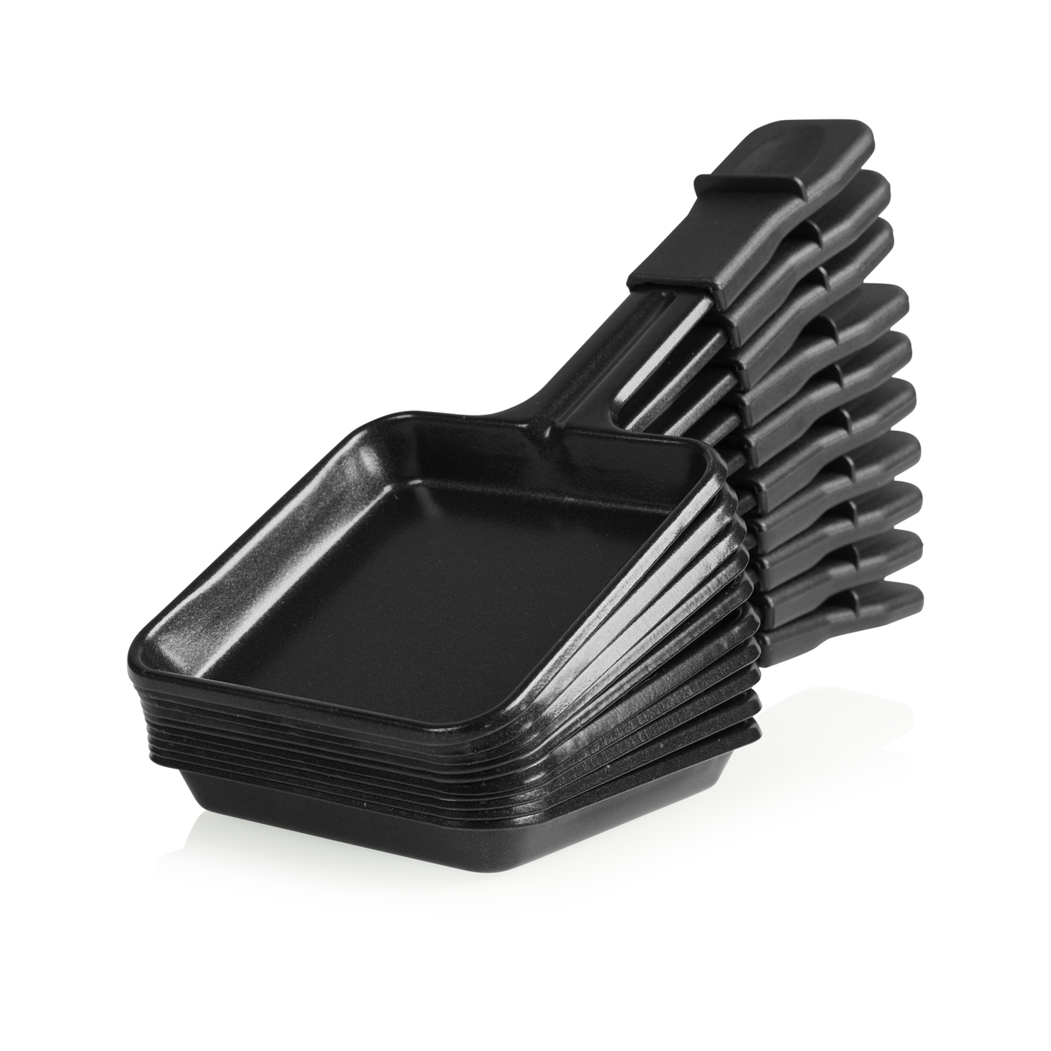 Black raclette pans stacked, with handles in a row, isolated on white background.