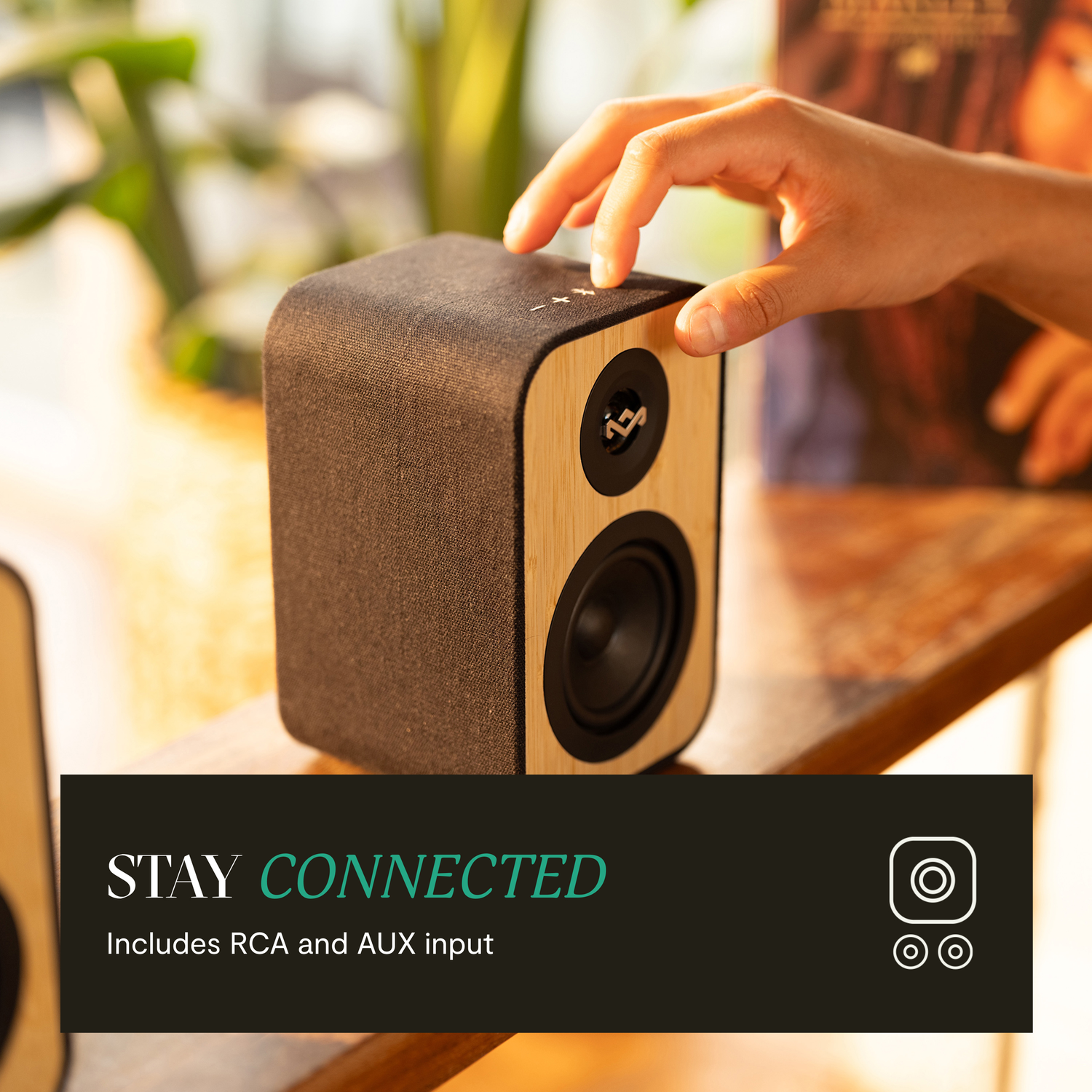 Houten luidspreker met een hand erop, tekst: STAY CONNECTED.