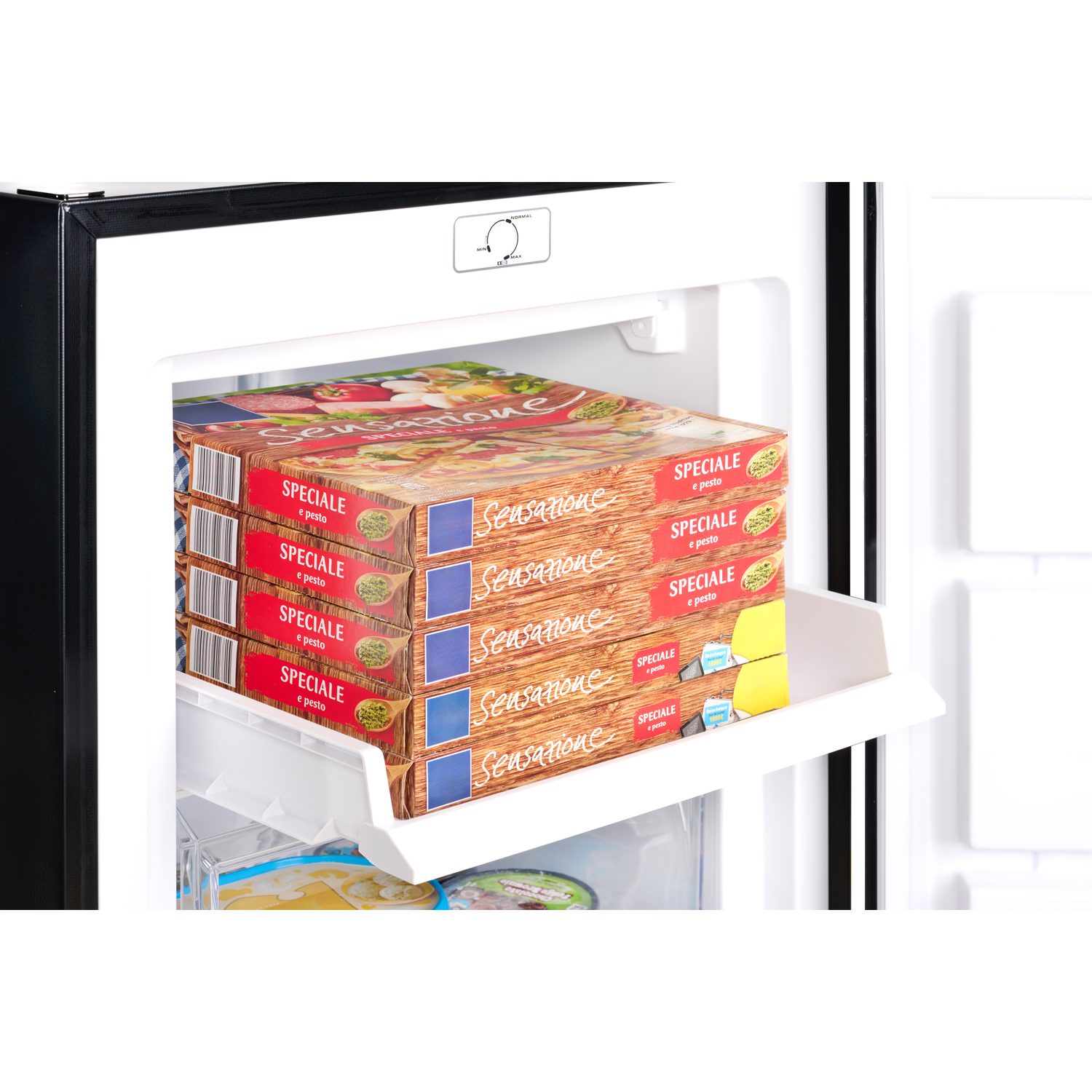 Freezer interior with frozen food boxes. Boxes are stacked inside a white drawer.