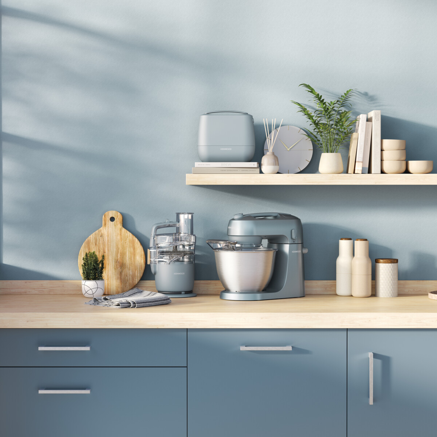 Keuken met diverse apparaten op planken en aanrechtbladen. Blauwe kasten en muur.