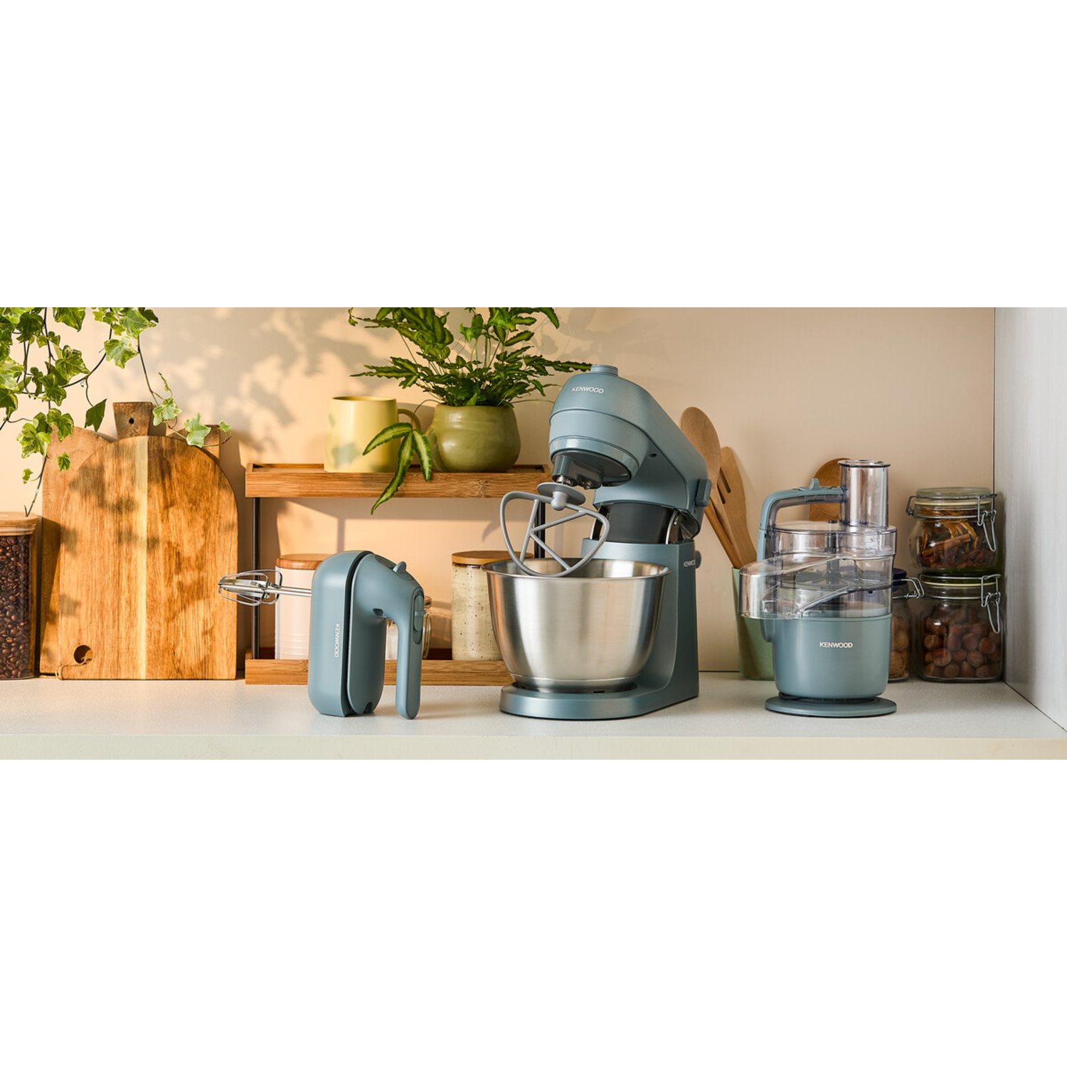 Keukenblad met een mixer, handmixer en keukenmachine, allemaal blauw.