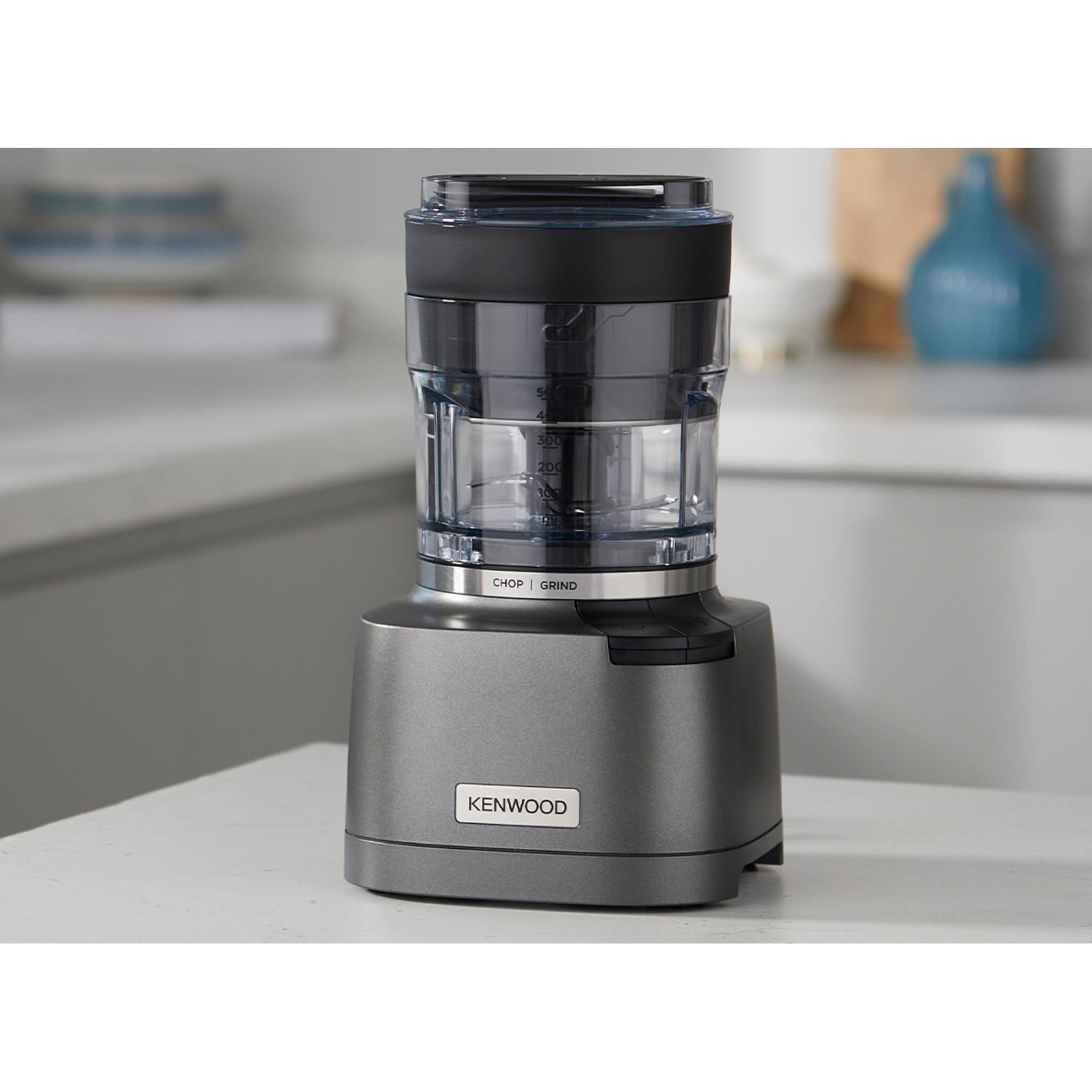 A gray Kenwood food processor on a white countertop.