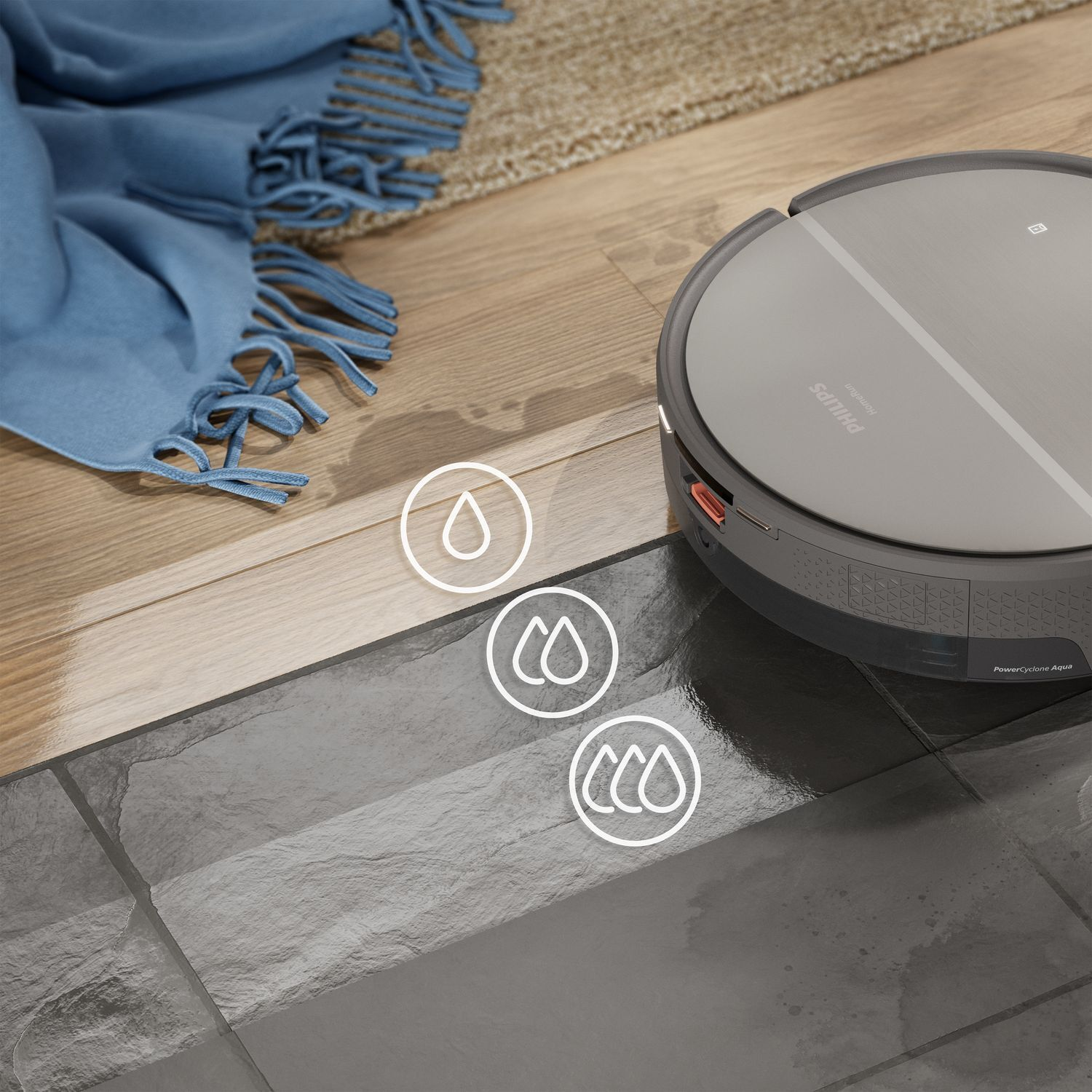 A robotic vacuum cleaner on a tile floor. There is a blue blanket and a wooden floor.