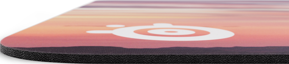 Nahaufnahme eines Mauspads mit einer bunten Sonnenuntergangsszene und einem weißen SteelSeries-Logo.