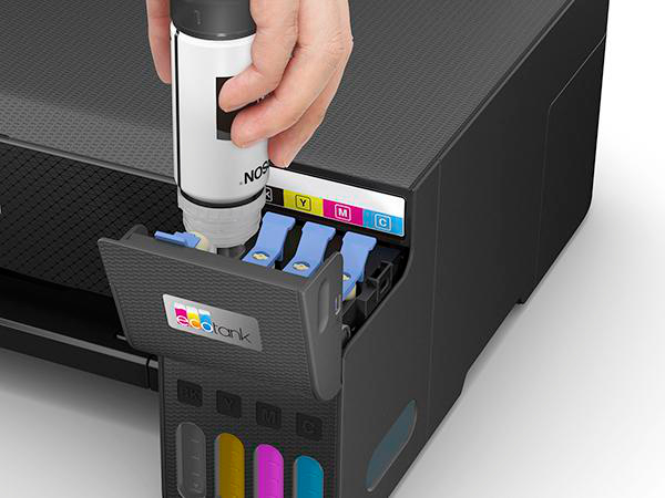 Eine Hand gießt schwarze Tinte in einen Drucker. Der Drucker ist schwarz und die Tinte in einer Flasche.