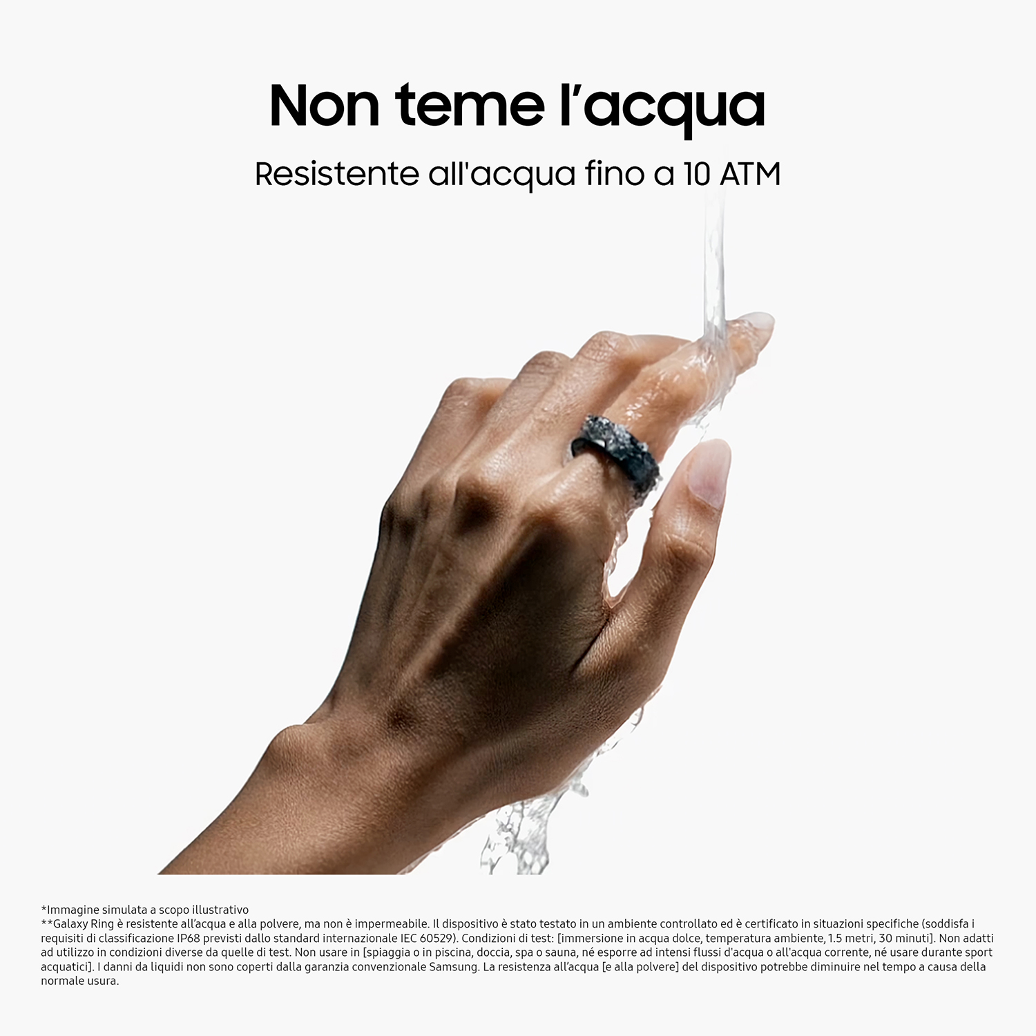 Mano con un anello su un dito che viene schizzata con acqua. L'anello è di colore grigio scuro.