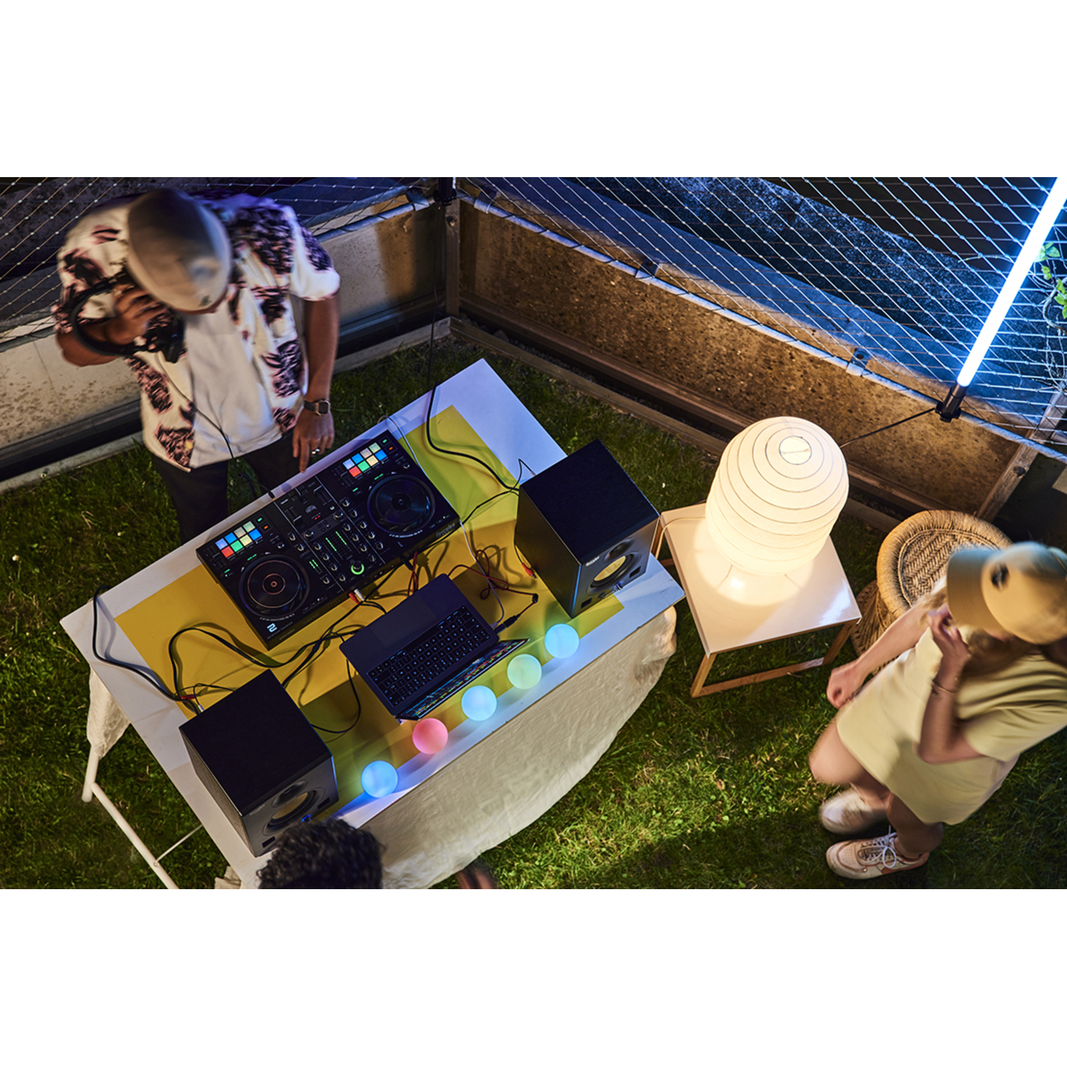A group of people at a rooftop party with DJ equipment.