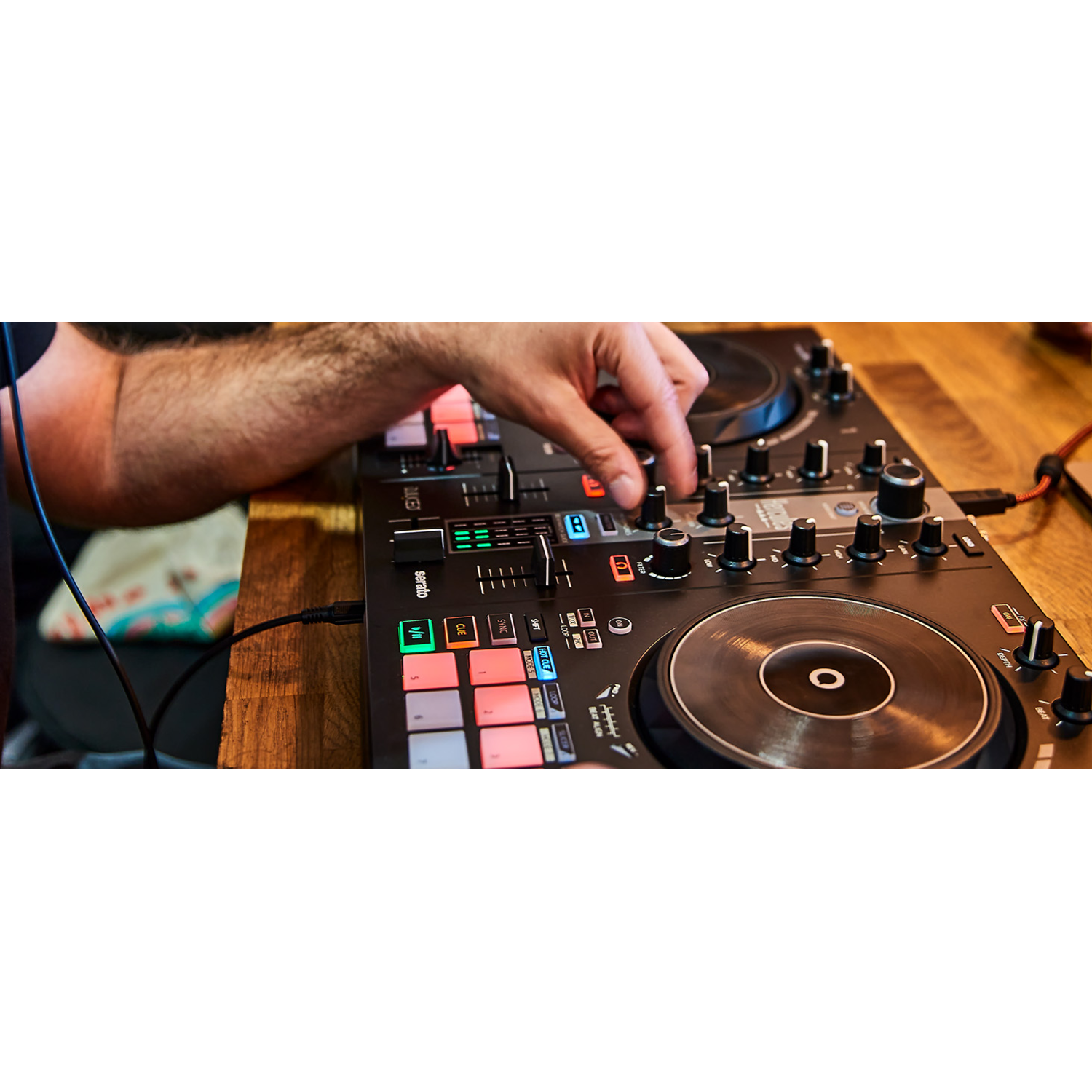 A person's hand adjusting a knob on a DJ mixing console.