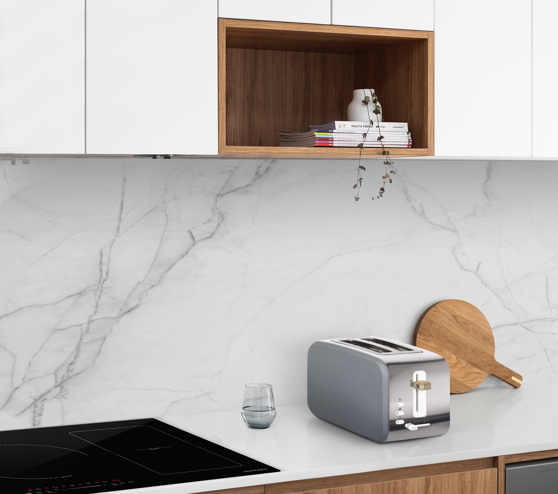 Un piano cucina con un tostapane, un tagliere e un bicchiere d'acqua sotto gli armadi.
